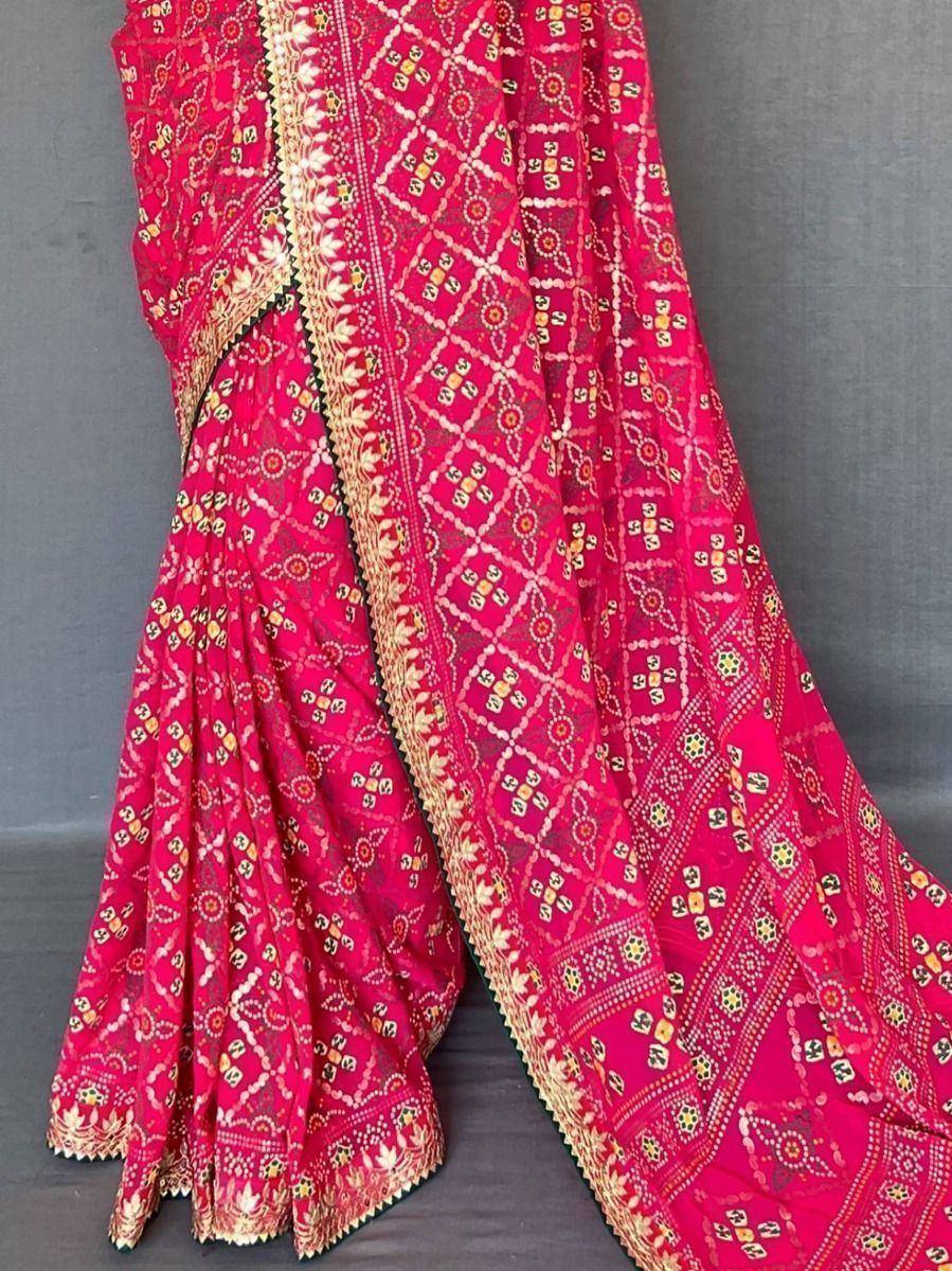 Vibrant pink ethnic saree with intricate geometric and floral prints, golden border detailing, perfect for Indian occasions.