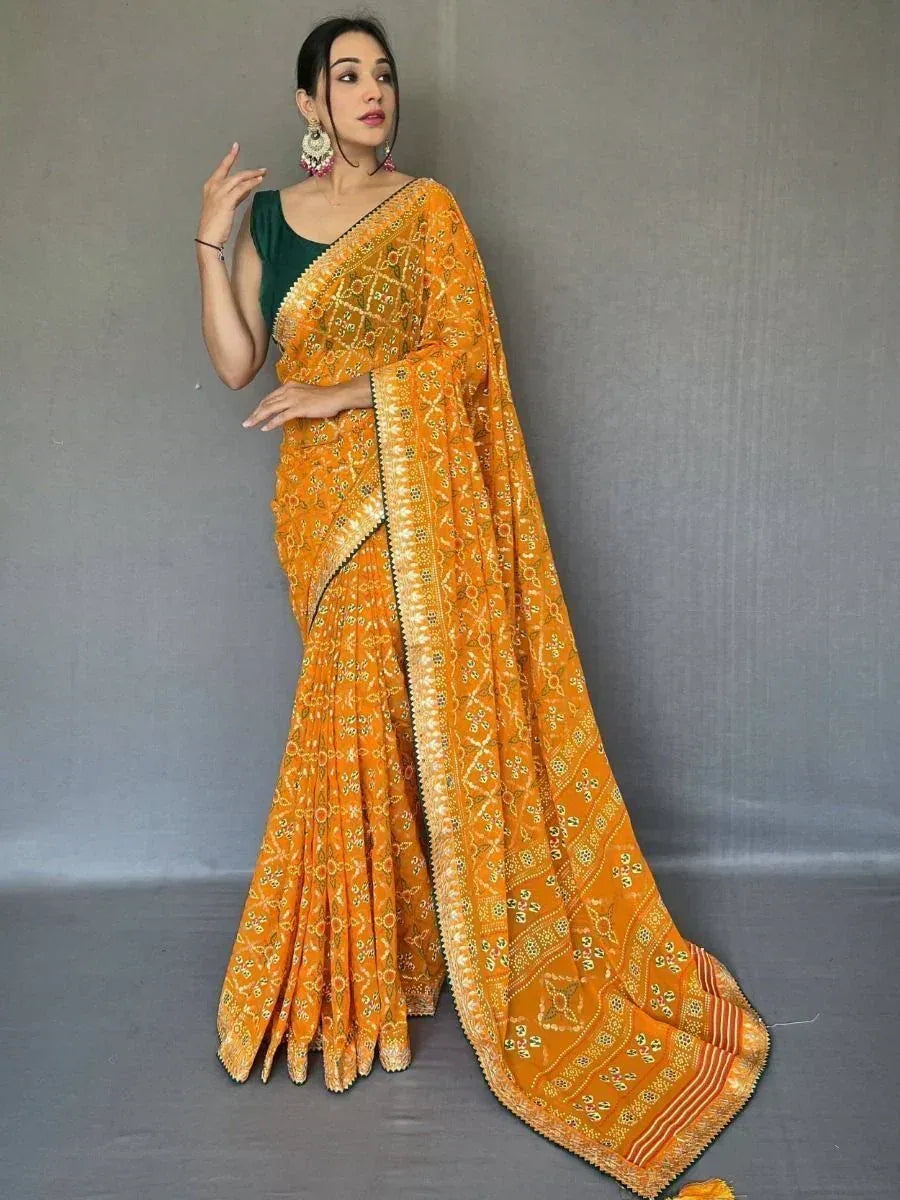 Vibrant orange printed saree with gold embroidery, paired with green blouse, perfect for Indian ethnic occasions.