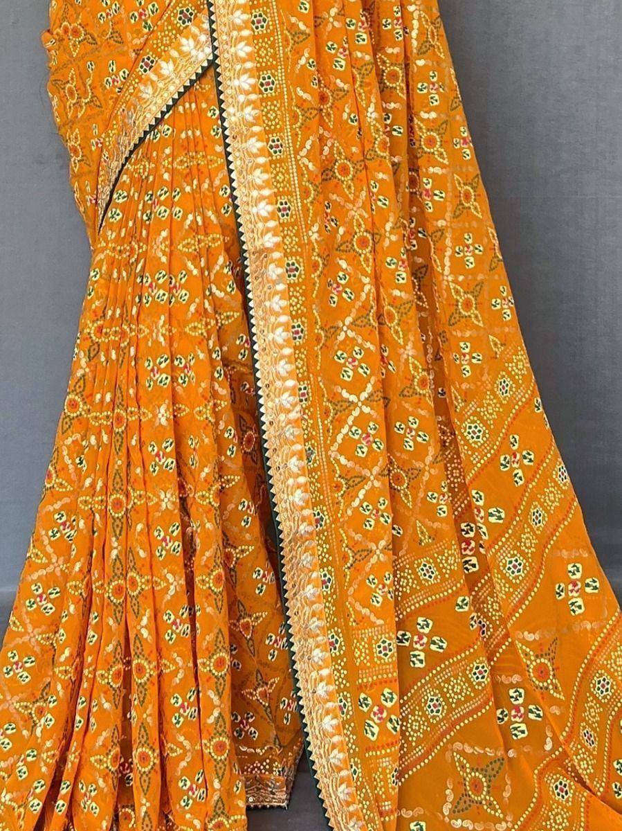 Vibrant orange ethnic saree with intricate floral and geometric prints, perfect for traditional Indian occasions.