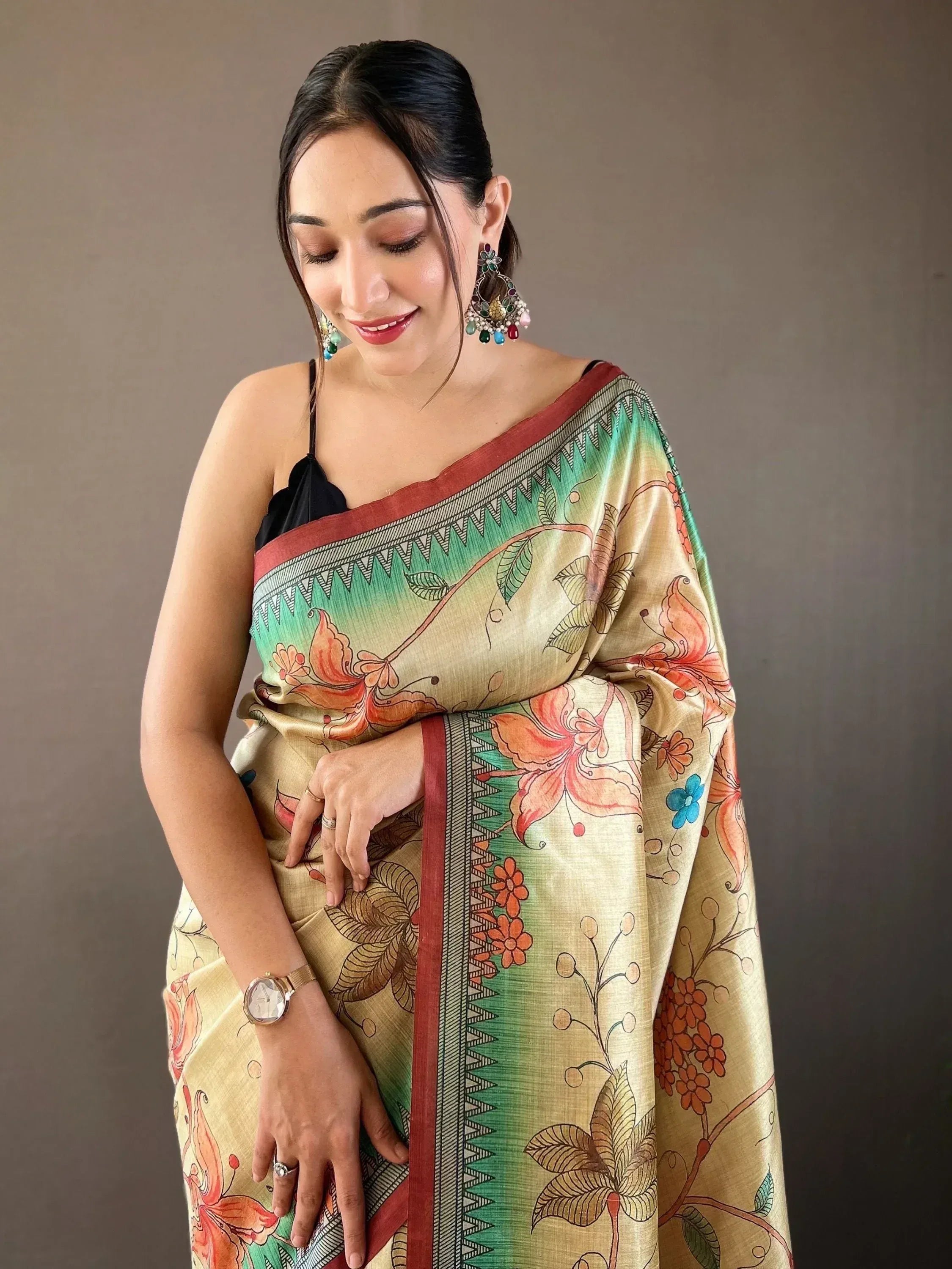 Woman in floral print saree with green and gold border, ethnic Indian wear