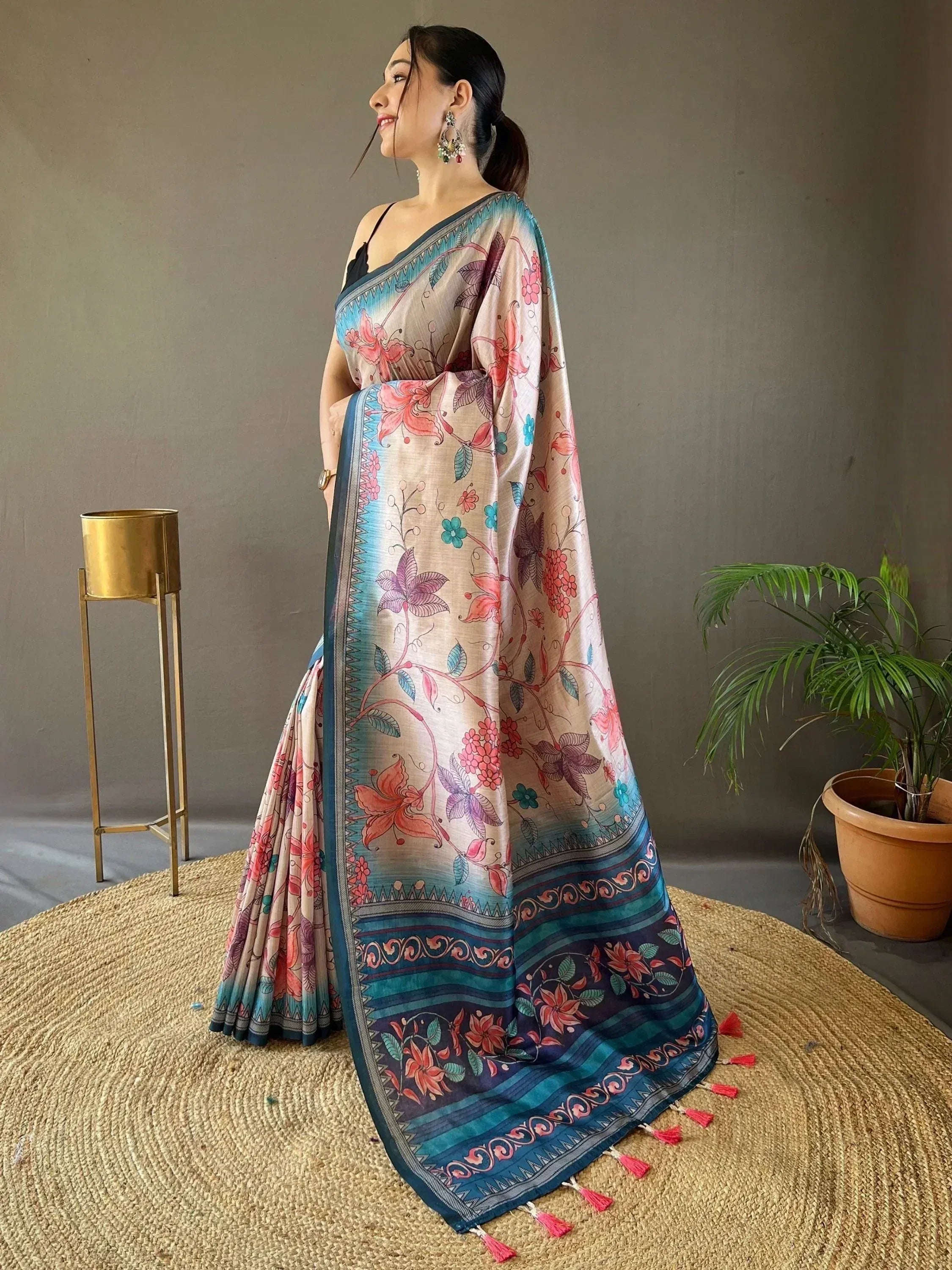 Woman in floral print saree with blue border and tassels, ethnic Indian wear