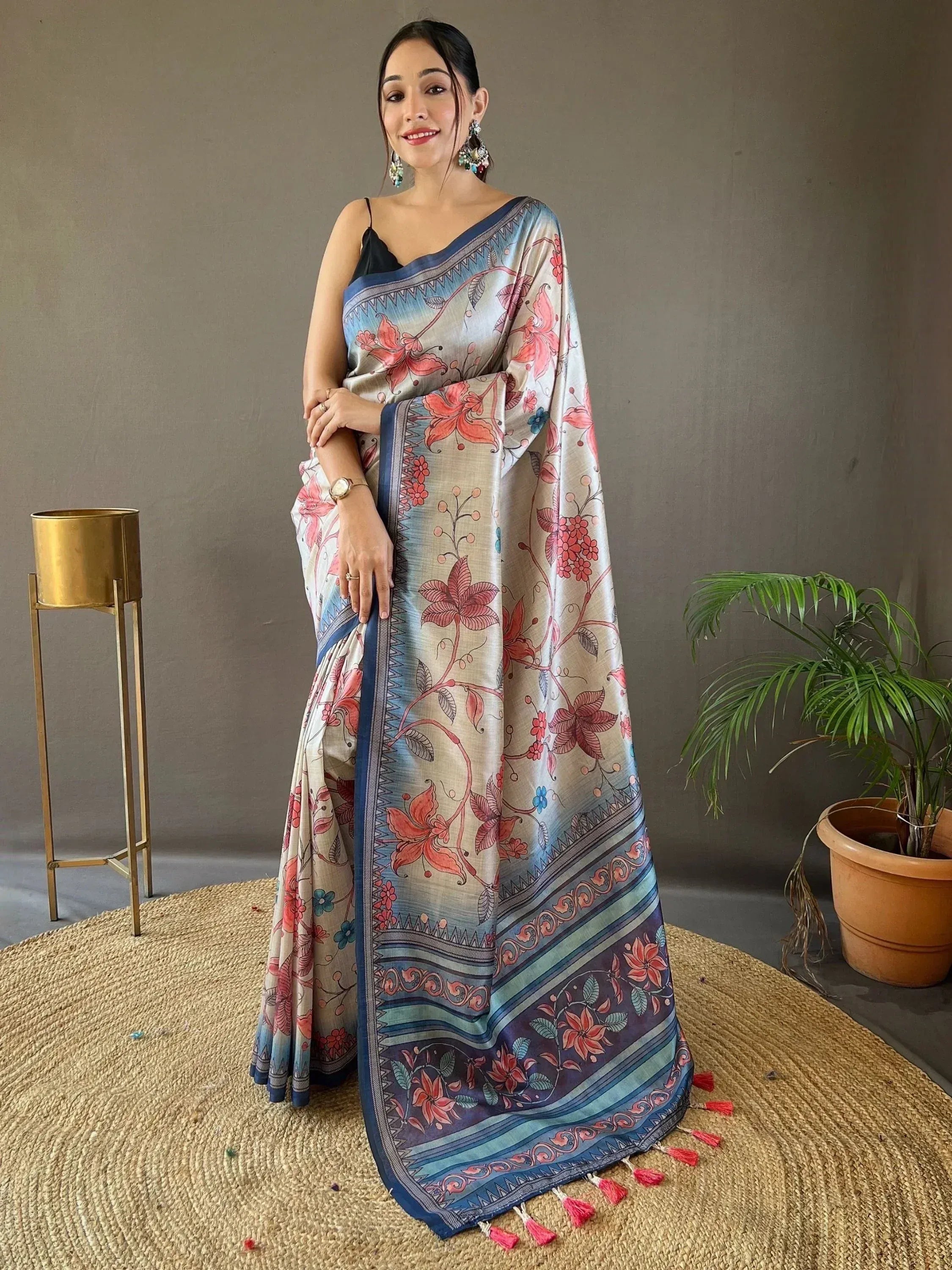 Woman in floral print saree with blue border and tassels, ethnic Indian wear