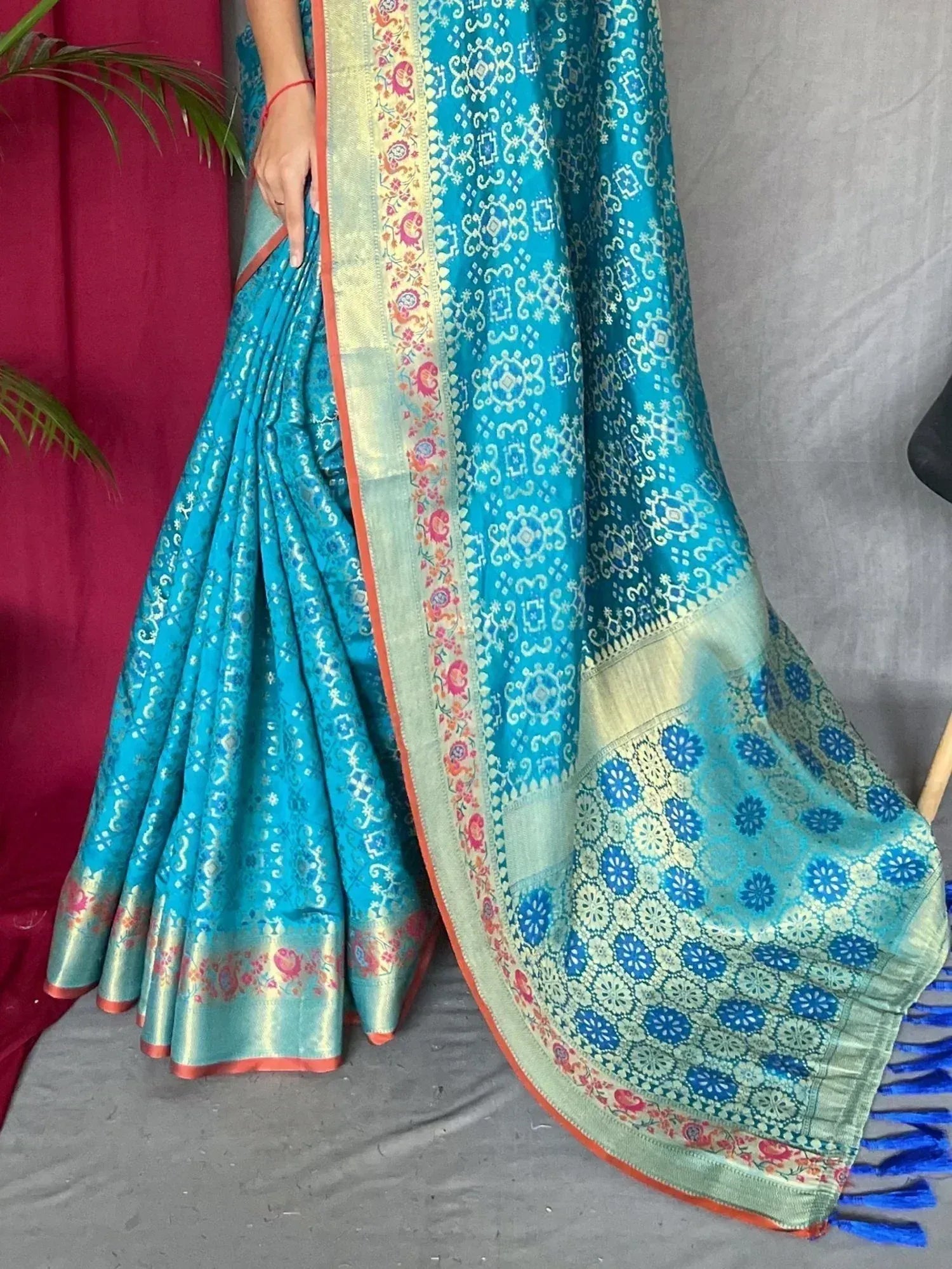 Turquoise designer saree with floral border and blue tassels, ethnic Indian wear