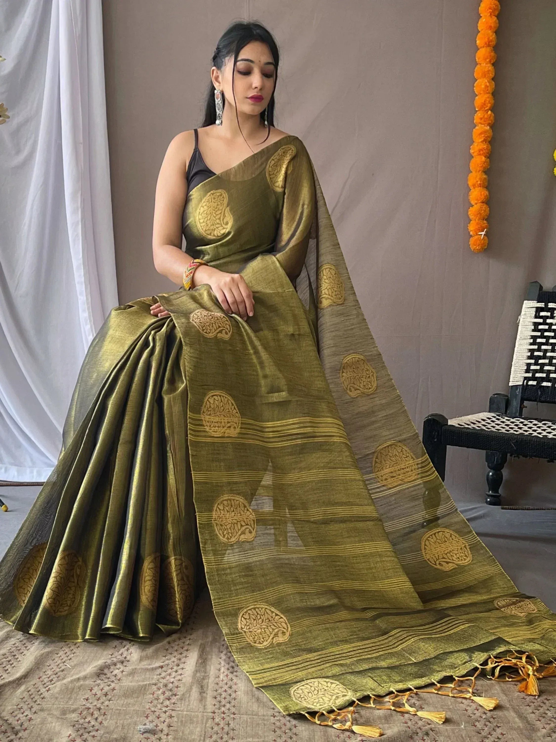 Olive green ethnic saree with gold paisley print and tassels, styled with black blouse for Indian occasions