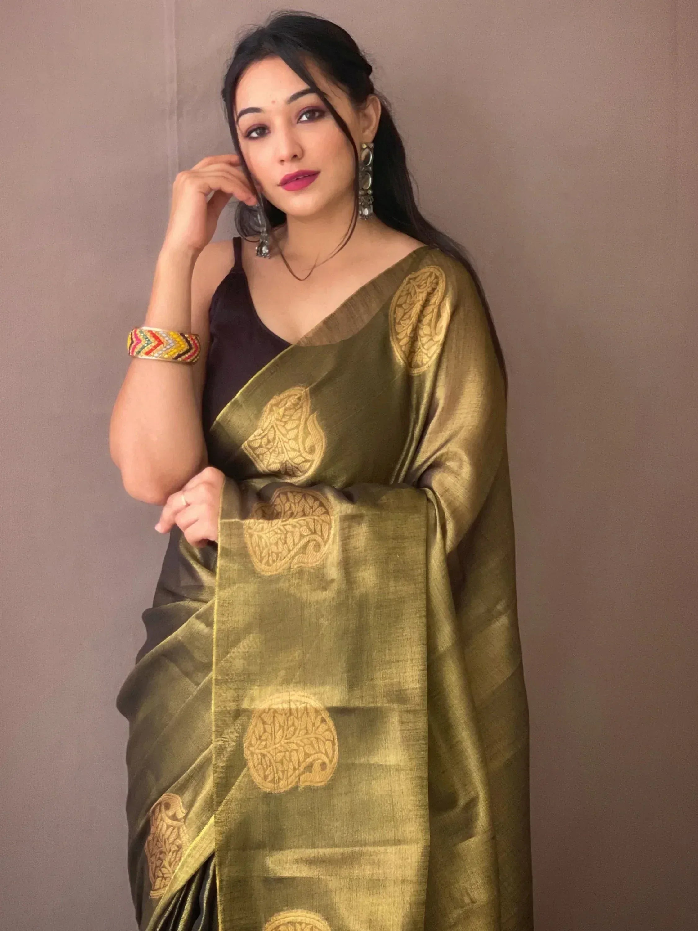 Olive green saree with gold floral motifs, paired with black blouse and statement earrings for ethnic wear