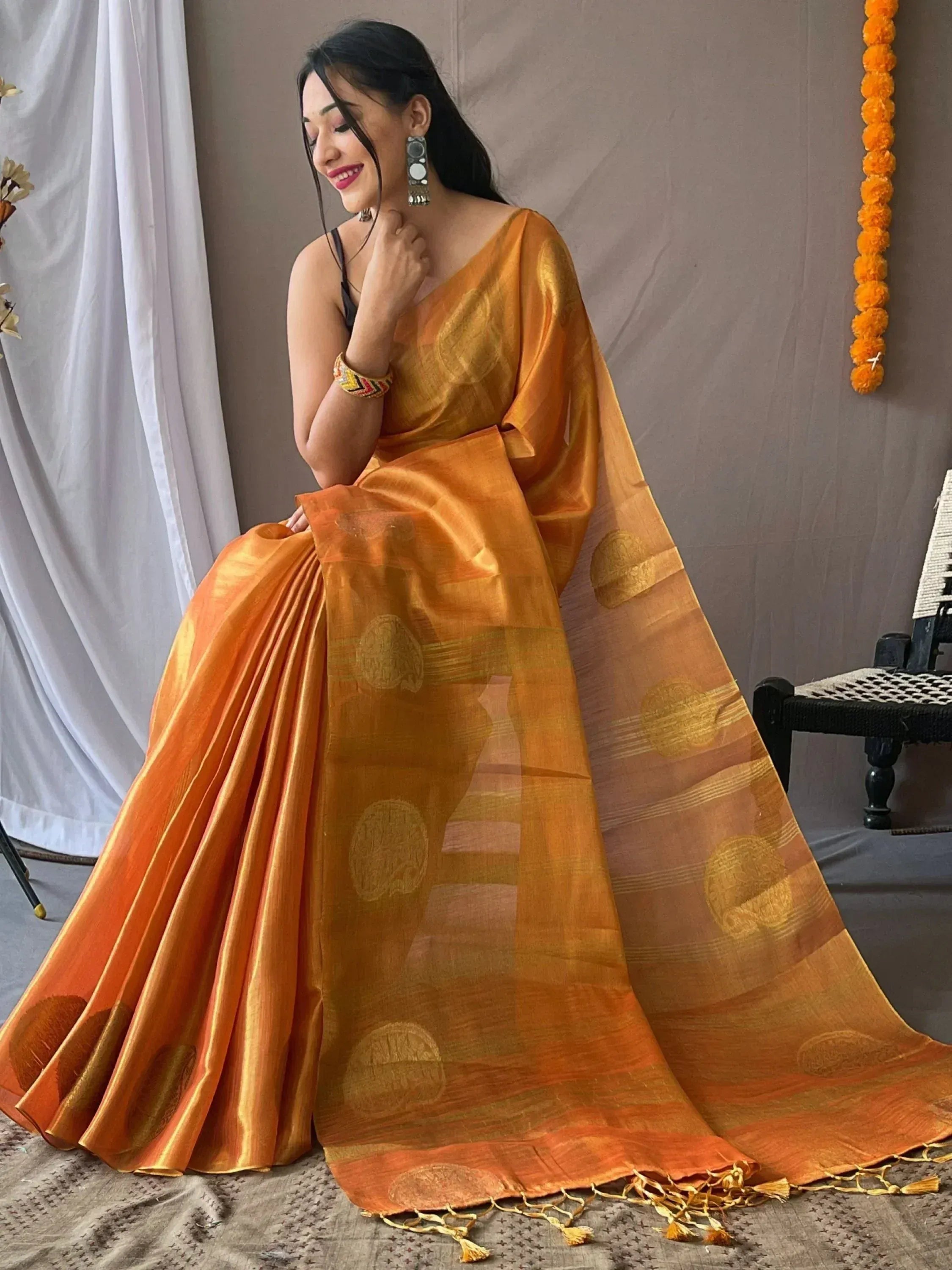 Woman in elegant orange designer saree with gold motifs, perfect for Indian ethnic wear occasions