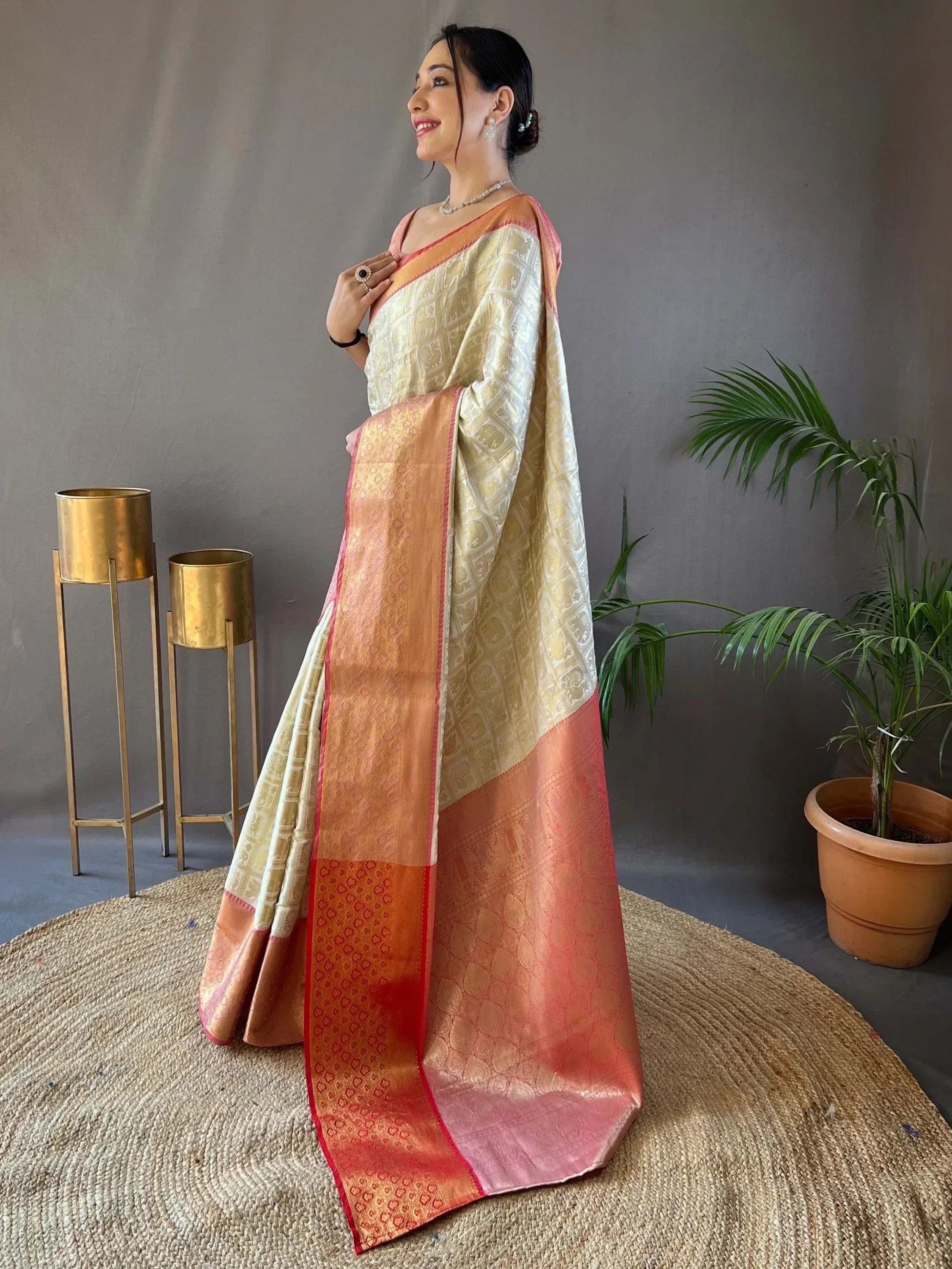 Elegant woman in designer silk saree with golden elephant motifs and peach border, perfect for Indian ethnic occasions.