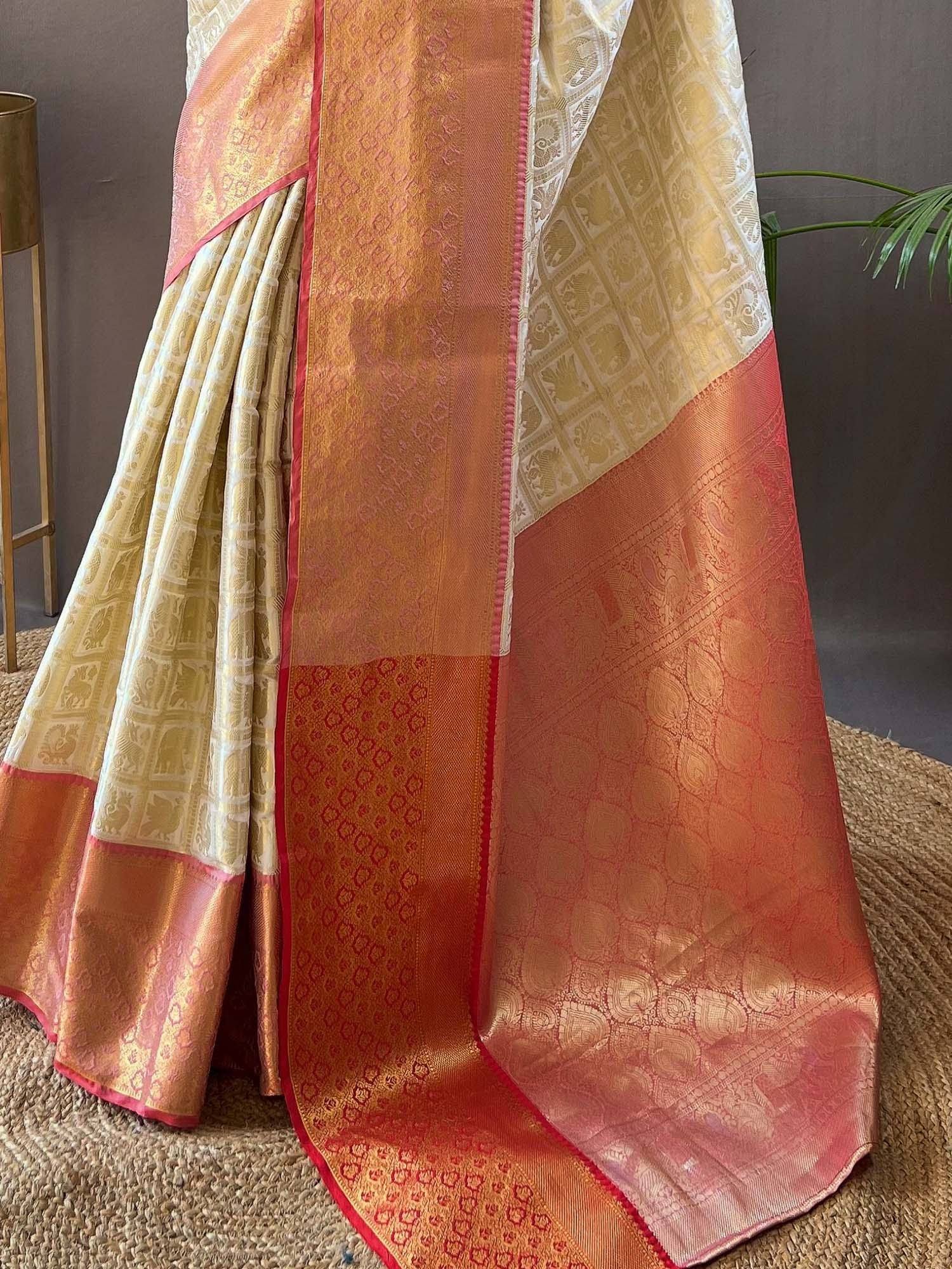 Elegant cream and orange silk saree with intricate elephant motifs and rich border, perfect for Indian ethnic wear.