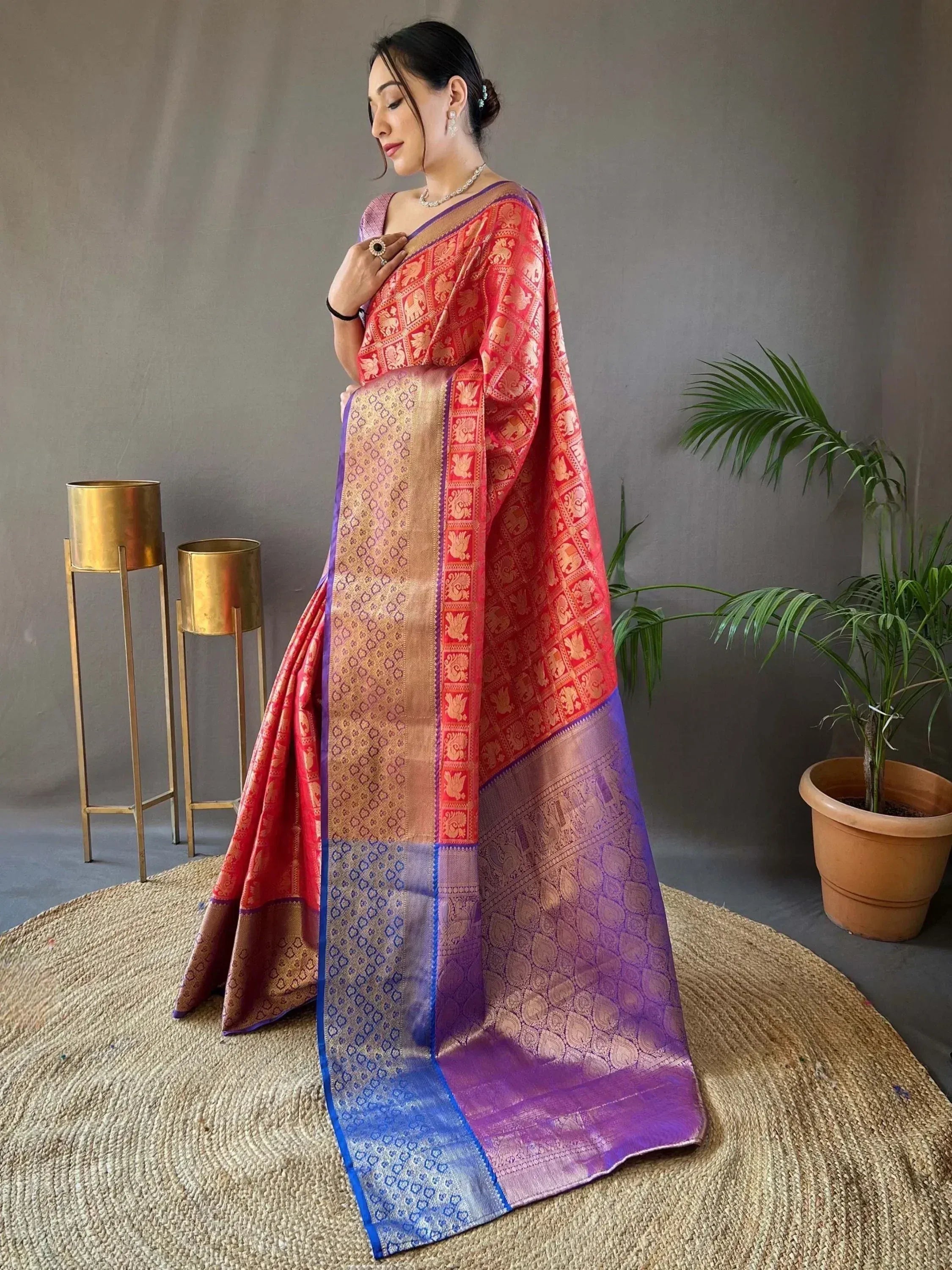 Woman in vibrant red and purple designer saree with elephant motifs, perfect for Indian ethnic wear occasions