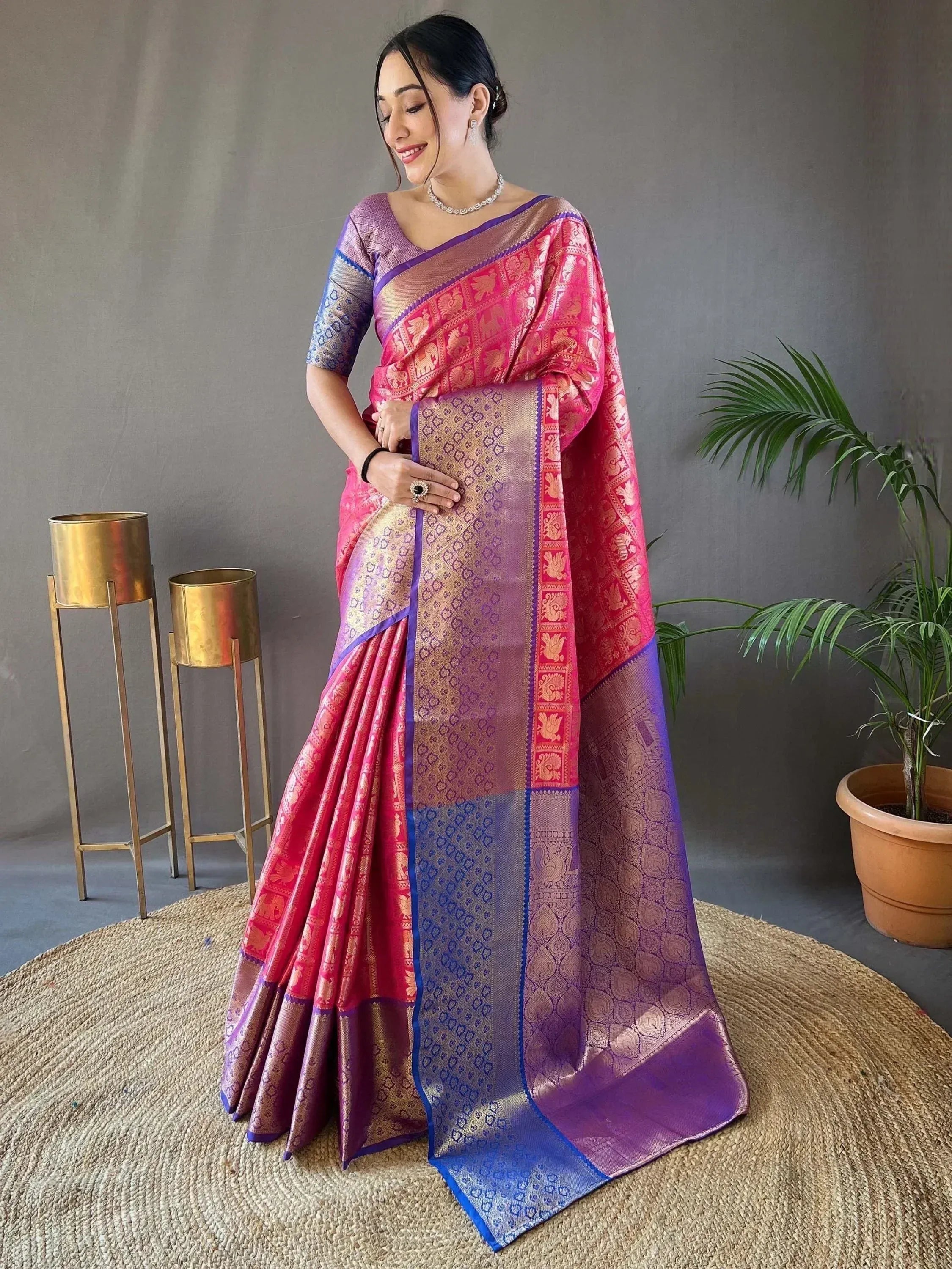Woman in vibrant pink and purple designer saree with gold elephant motifs, perfect for Indian ethnic occasions
