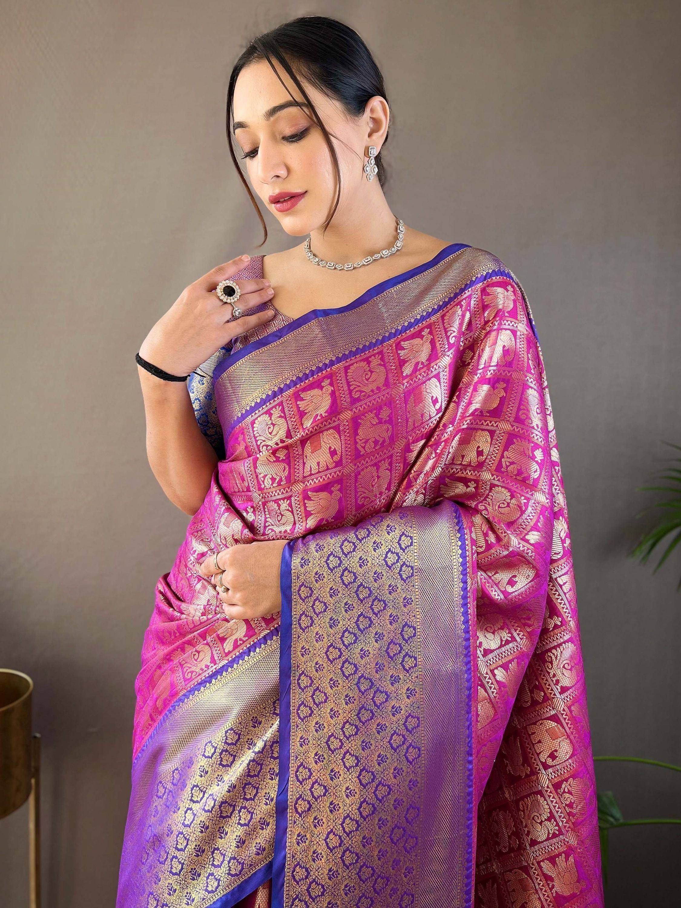 Woman in vibrant pink and purple designer saree with gold elephant motifs, perfect for Indian ethnic wear occasions.