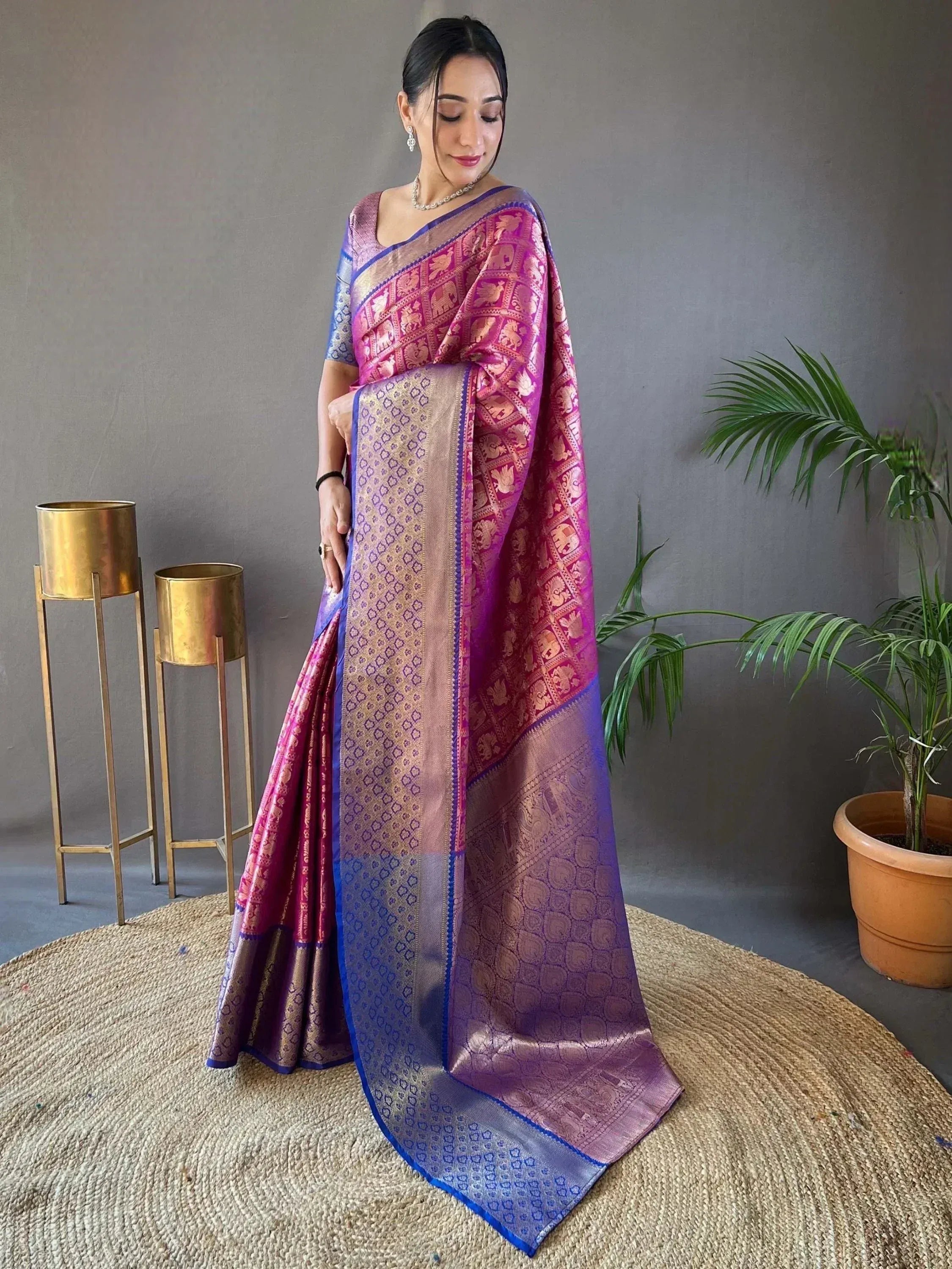 Elegant purple and pink designer saree with intricate elephant motifs and golden border