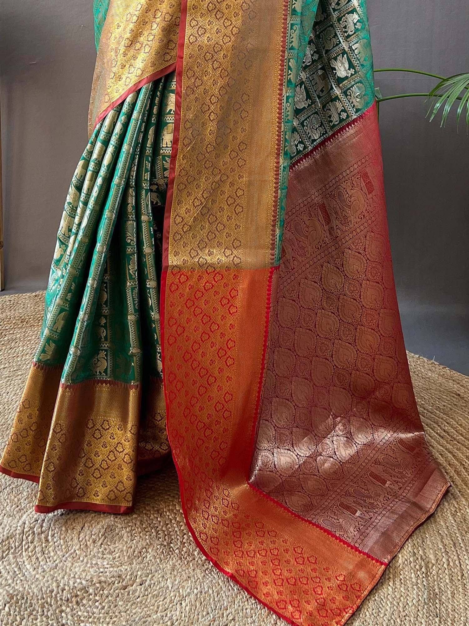 Green and gold designer saree with intricate paisley and elephant motifs, perfect for ethnic wear.