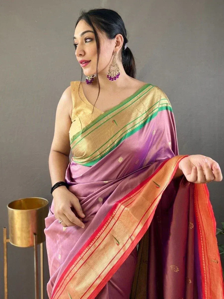 Woman in elegant purple and gold silk saree with green border, styled with statement earrings for ethnic occasions