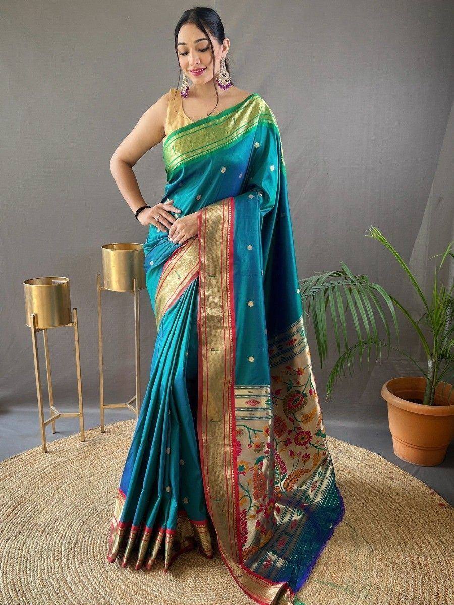 Teal silk saree with gold border and floral pallu, styled with statement earrings for ethnic occasions