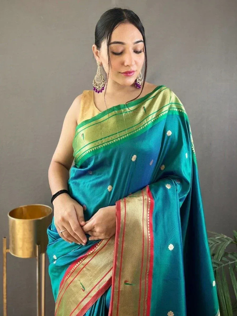 Teal silk saree with gold border and floral motifs, paired with gold blouse and statement earrings