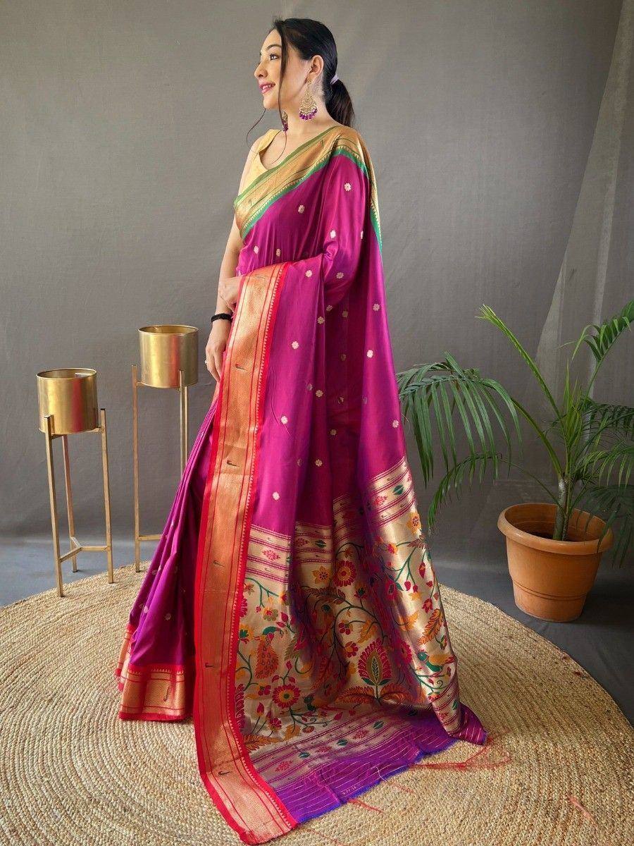 Woman in vibrant magenta silk saree with floral border, gold blouse, and traditional jewelry, styled for Indian ethnic wear.