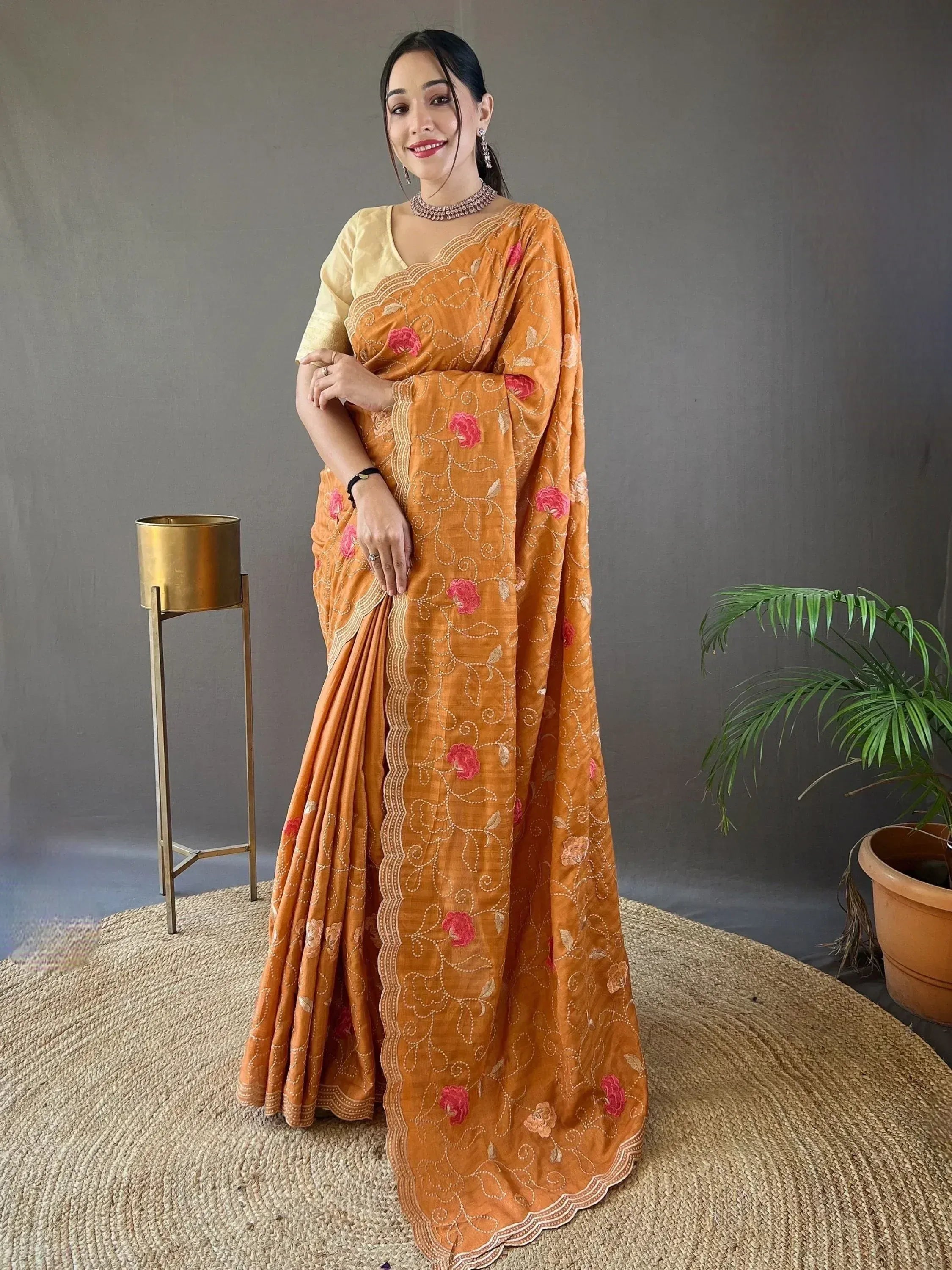 Woman in orange floral embroidered saree with yellow blouse, ethnic Indian wear