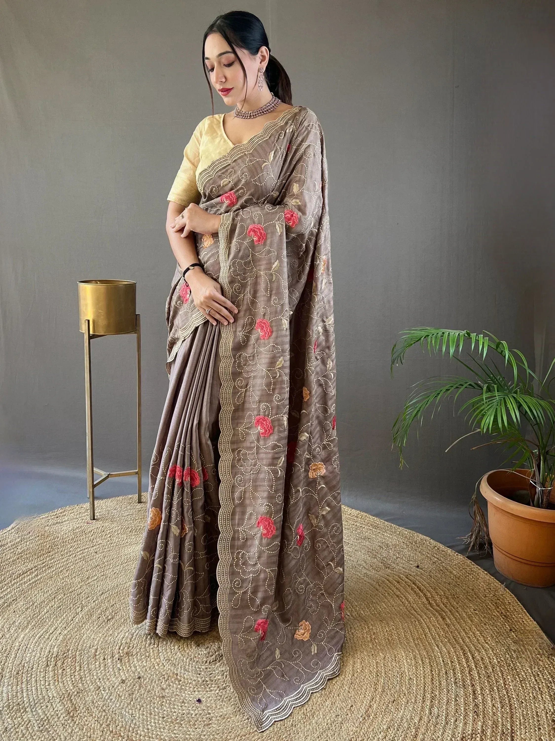 Brown embroidered saree with floral motifs and gold border, paired with yellow blouse, Indian ethnic wear