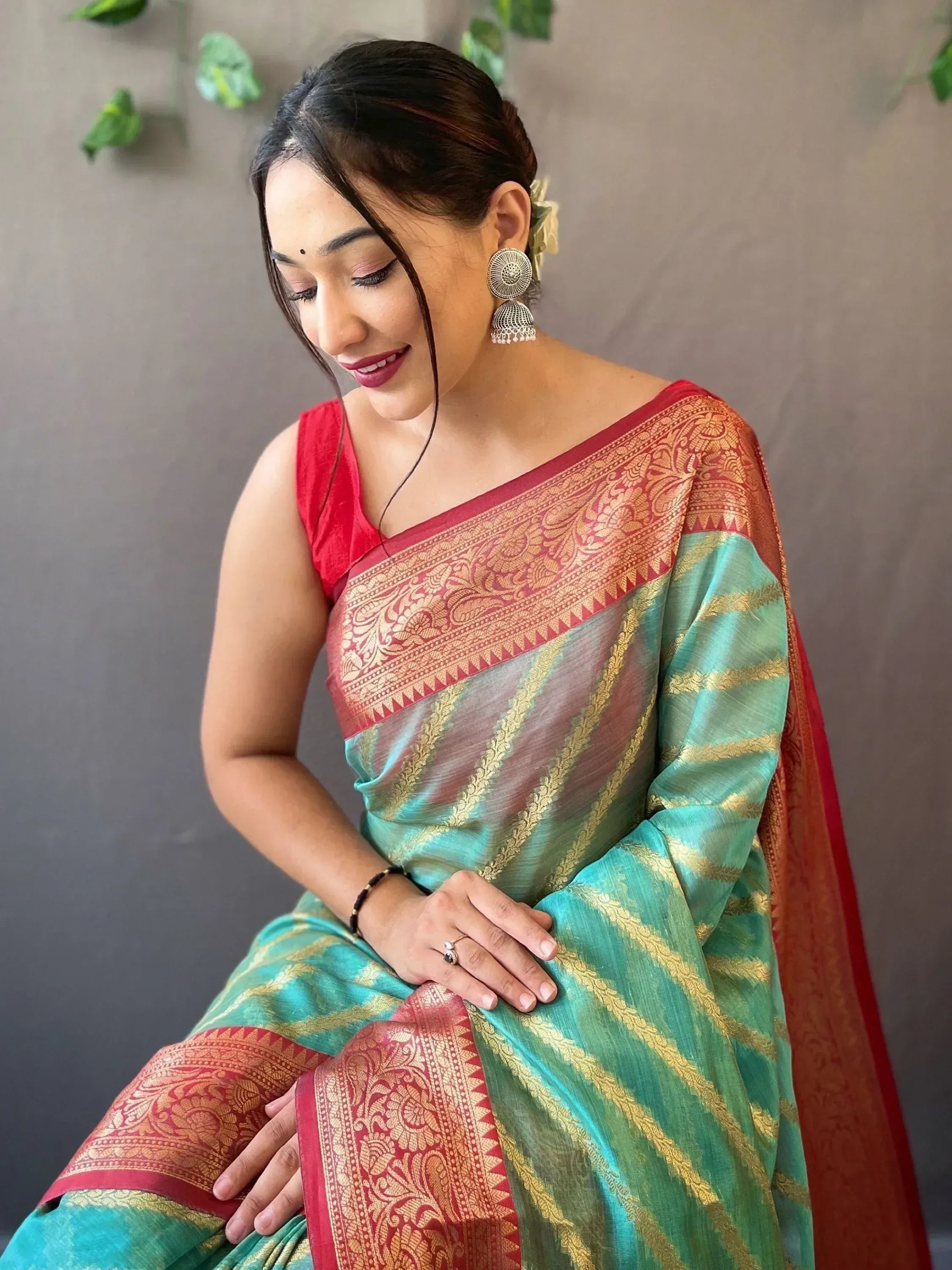 Woman in green and red designer saree with gold zari, ethnic wear for festive occasions