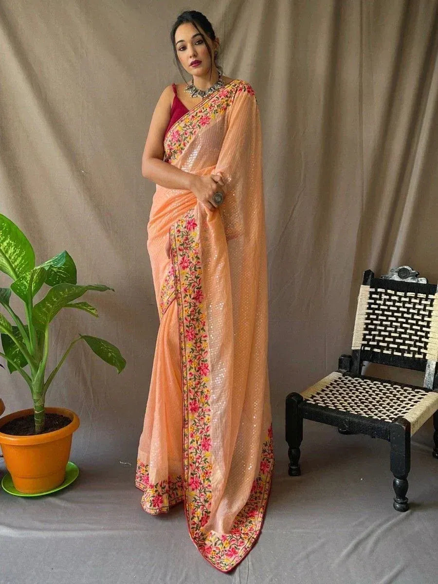 Peach floral embroidered saree with sequin detailing, styled with red blouse and statement necklace