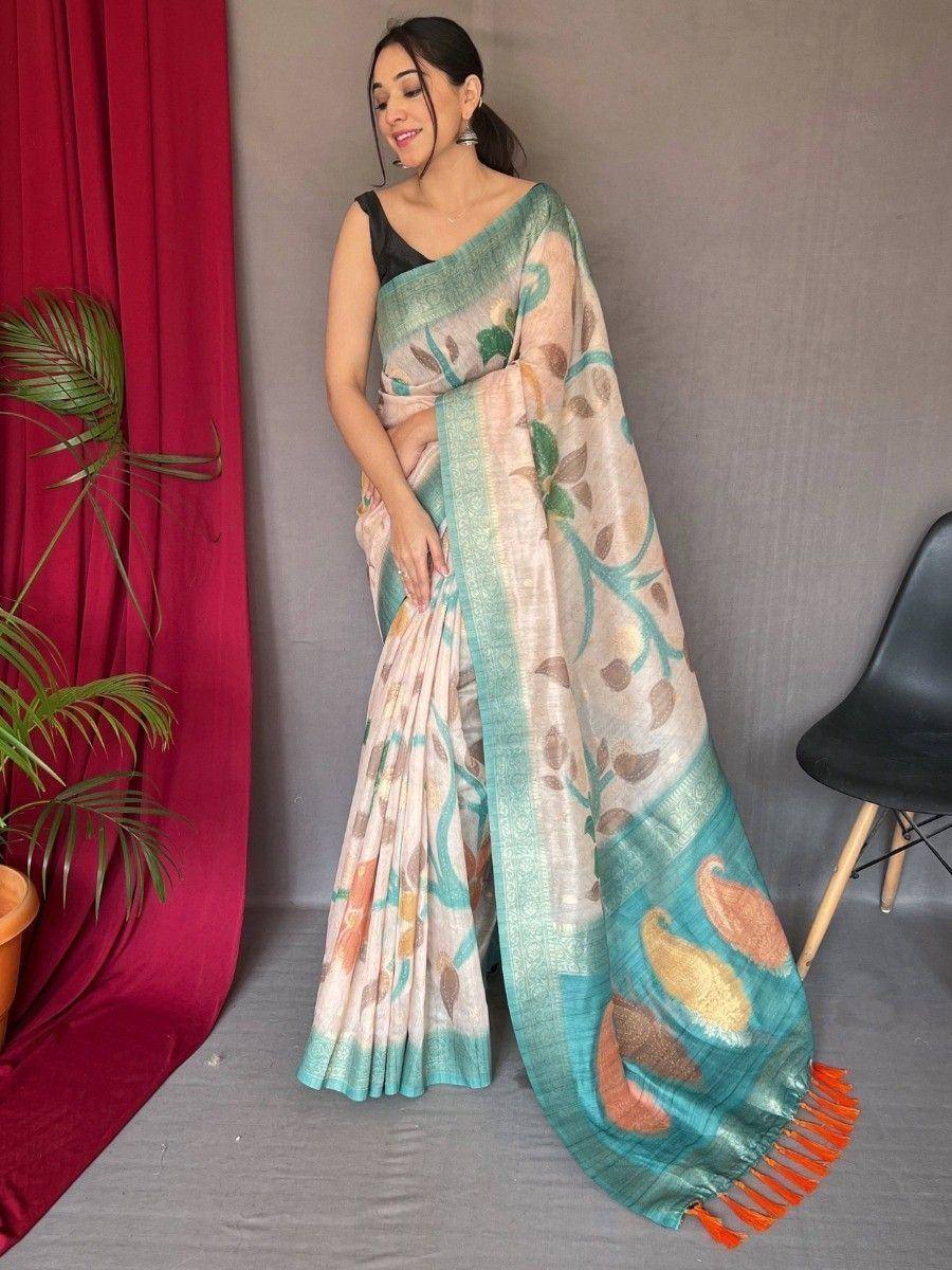 Woman wearing floral print saree with peacock motifs, teal border, and orange tassels, styled with black blouse