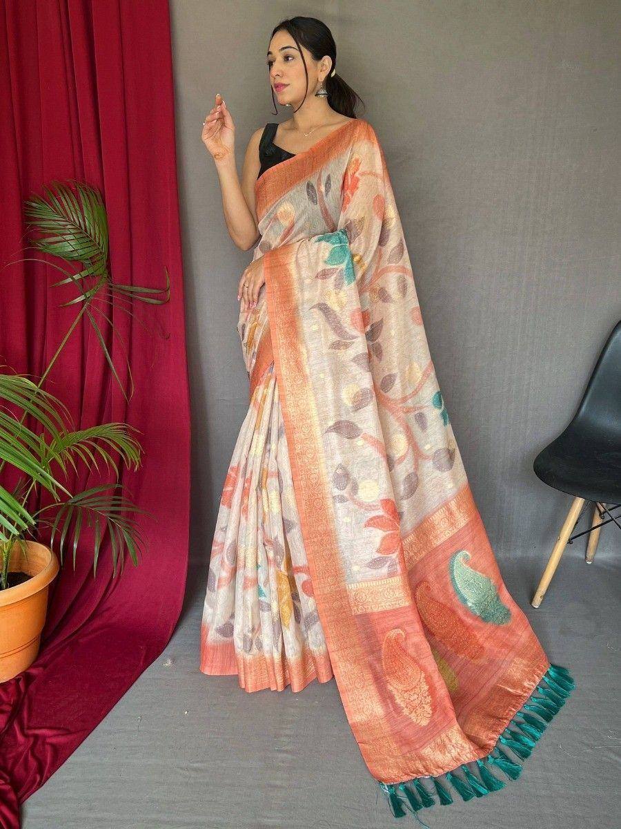 Woman in elegant printed saree with peacock motifs, orange border, and green tassels, styled for Indian ethnic wear.