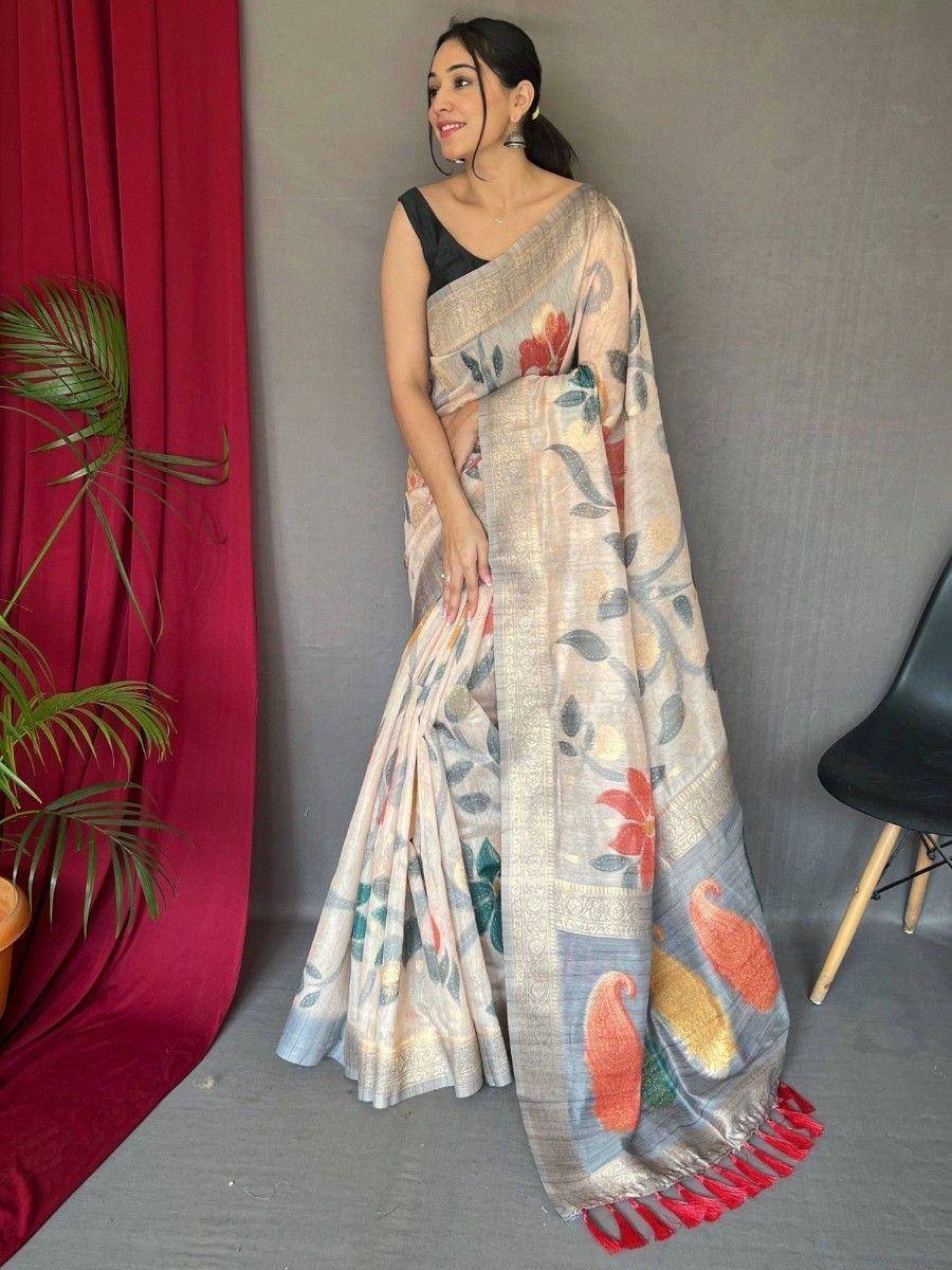 Woman wearing floral printed saree with red tassels, paired with black blouse, ideal for ethnic occasions