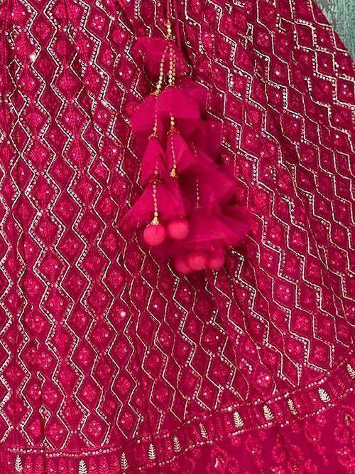 Pink ethnic lehenga with gold geometric embroidery and tassel details