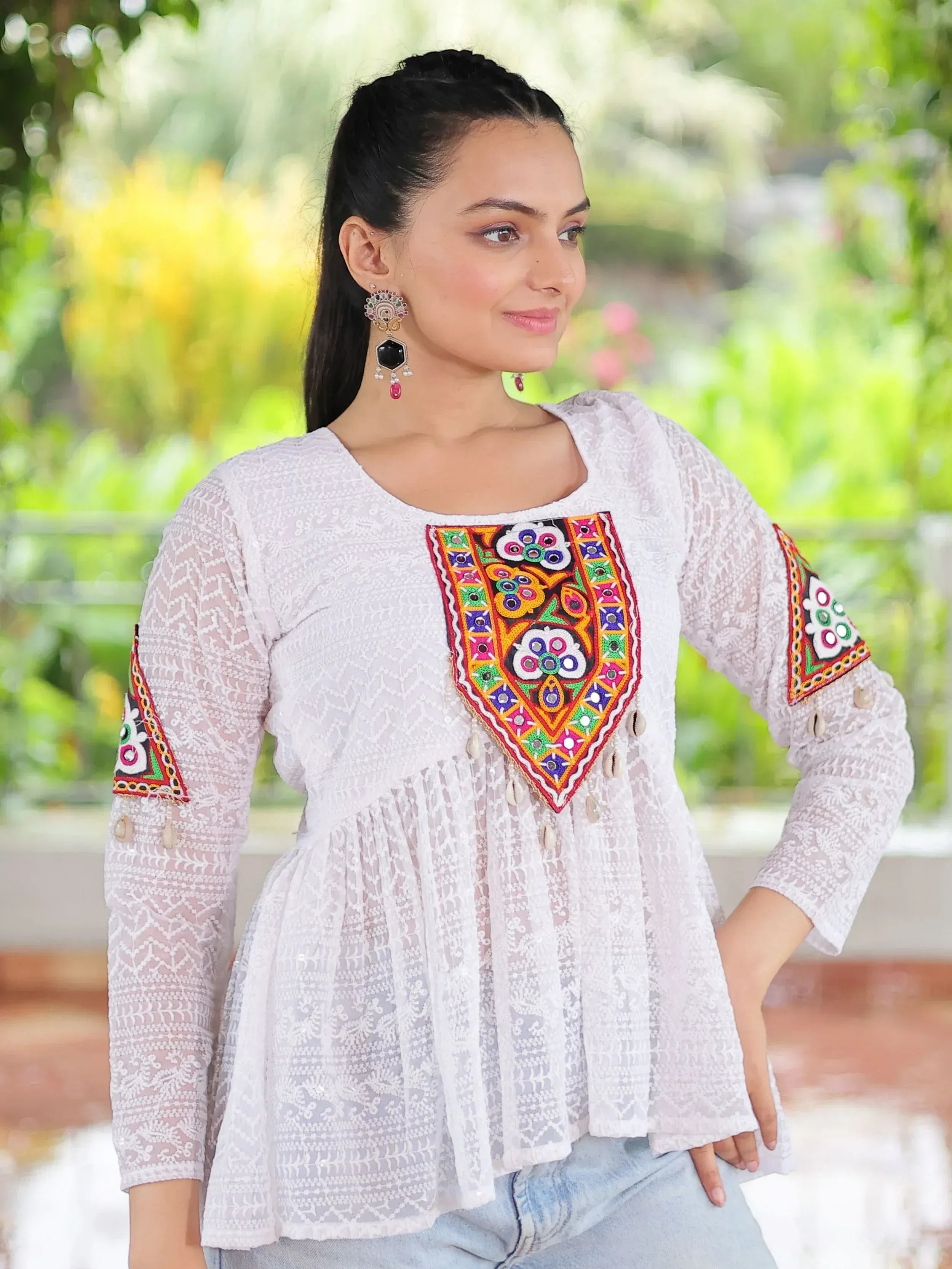 White ethnic kurti with colorful mirror embroidery and lace detailing, perfect for casual Indian wear.