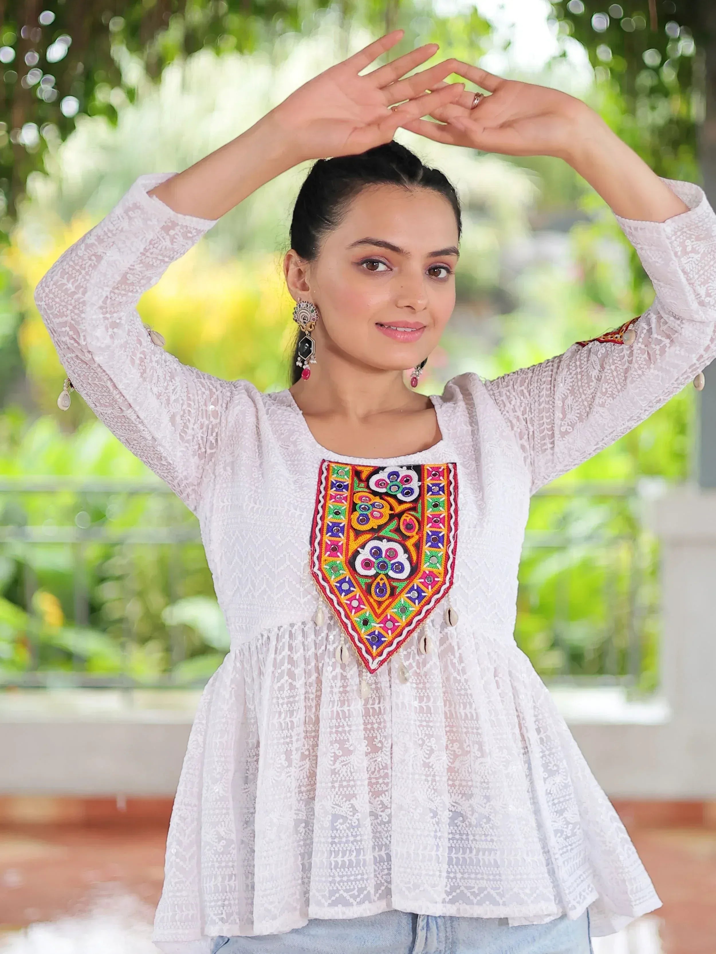 White ethnic top with colorful mirror work and lace detailing, perfect for Indian festive wear