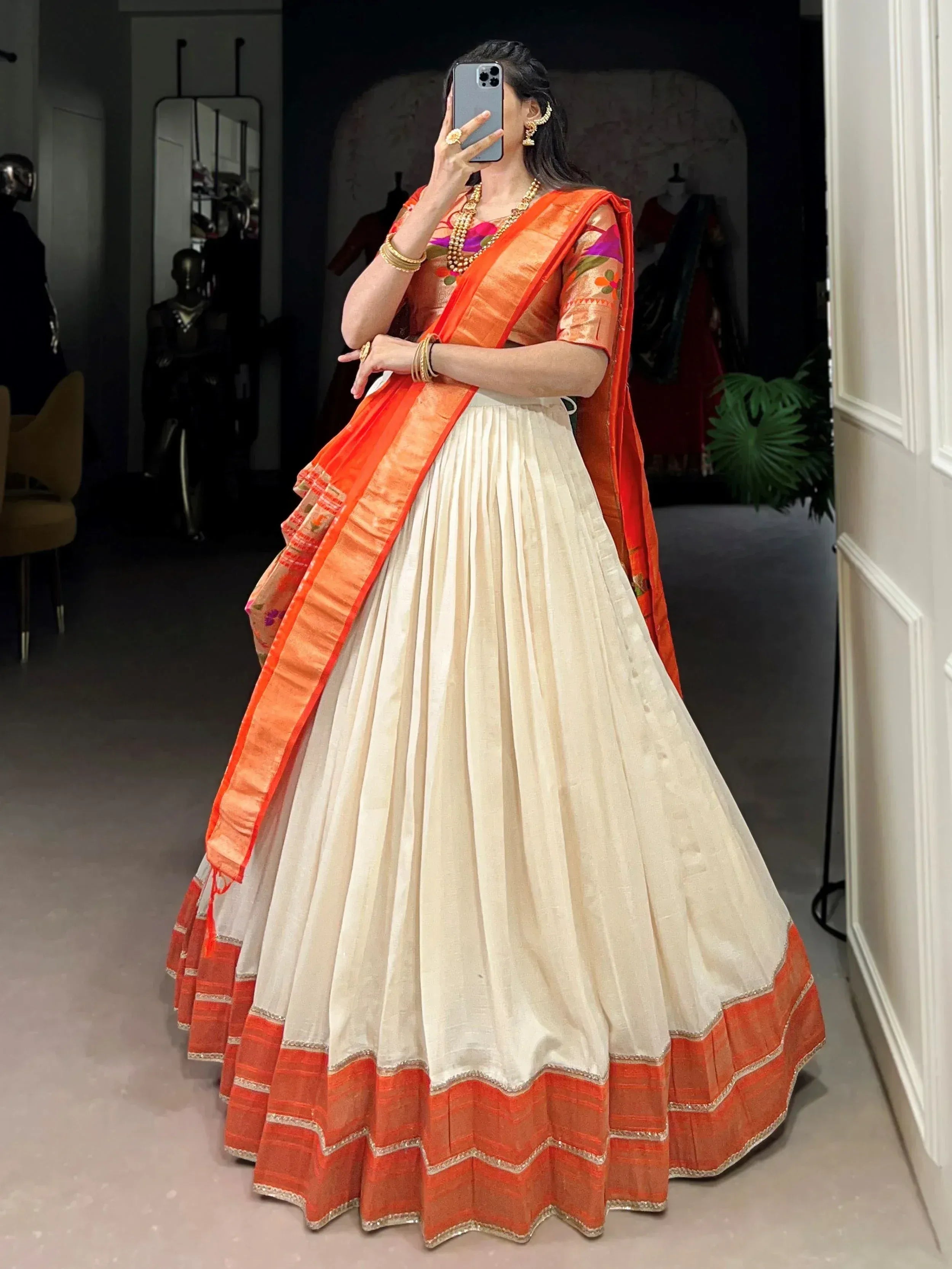 Woman in orange and cream designer lehenga choli with floral blouse, perfect for Indian ethnic wear occasions