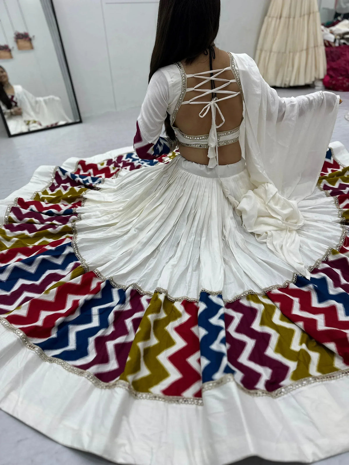 White ethnic lehenga choli with colorful chevron border and back lace-up design