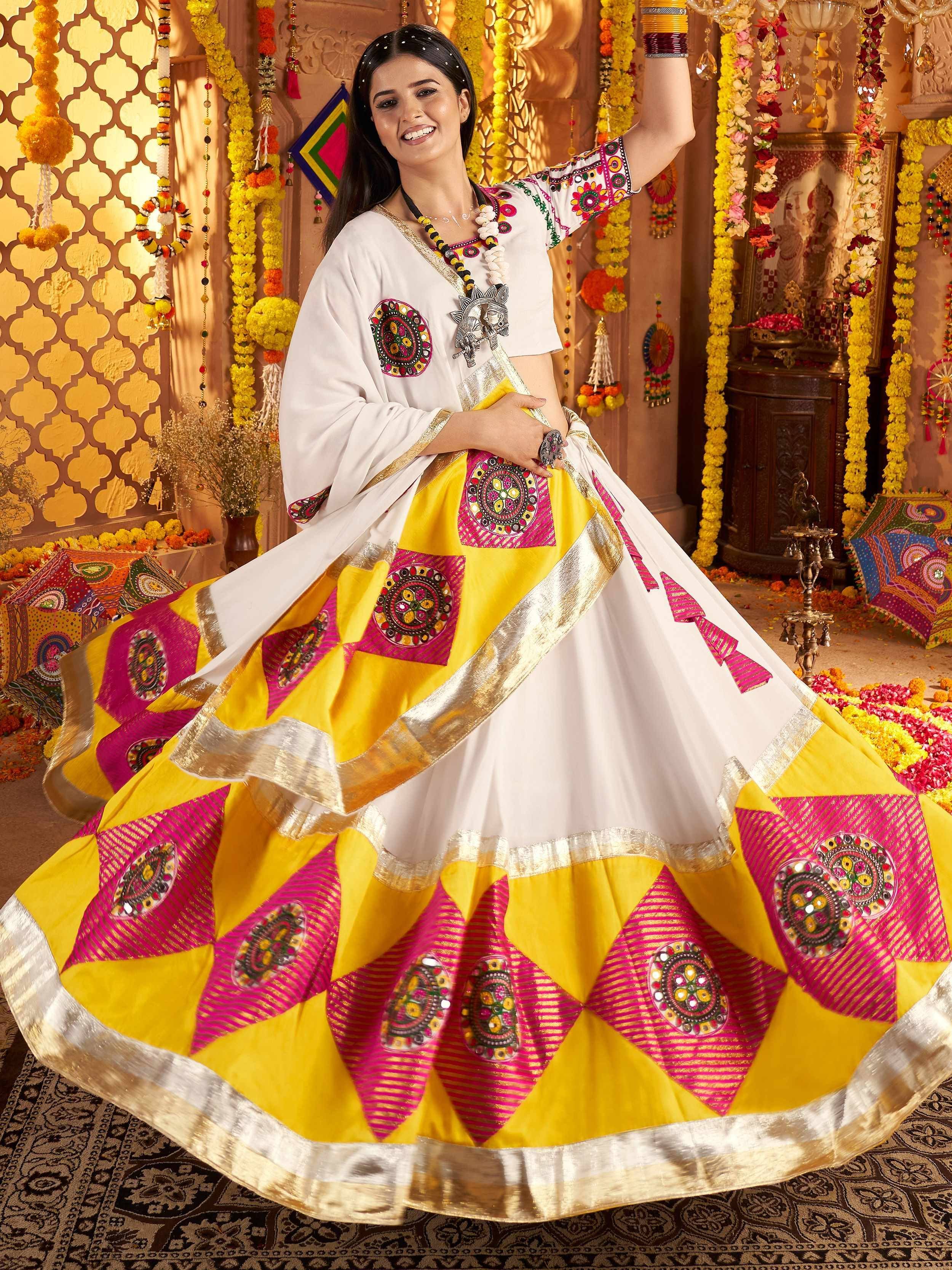 Woman in vibrant yellow and pink embroidered ethnic lehenga choli, perfect for festive occasions and celebrations.