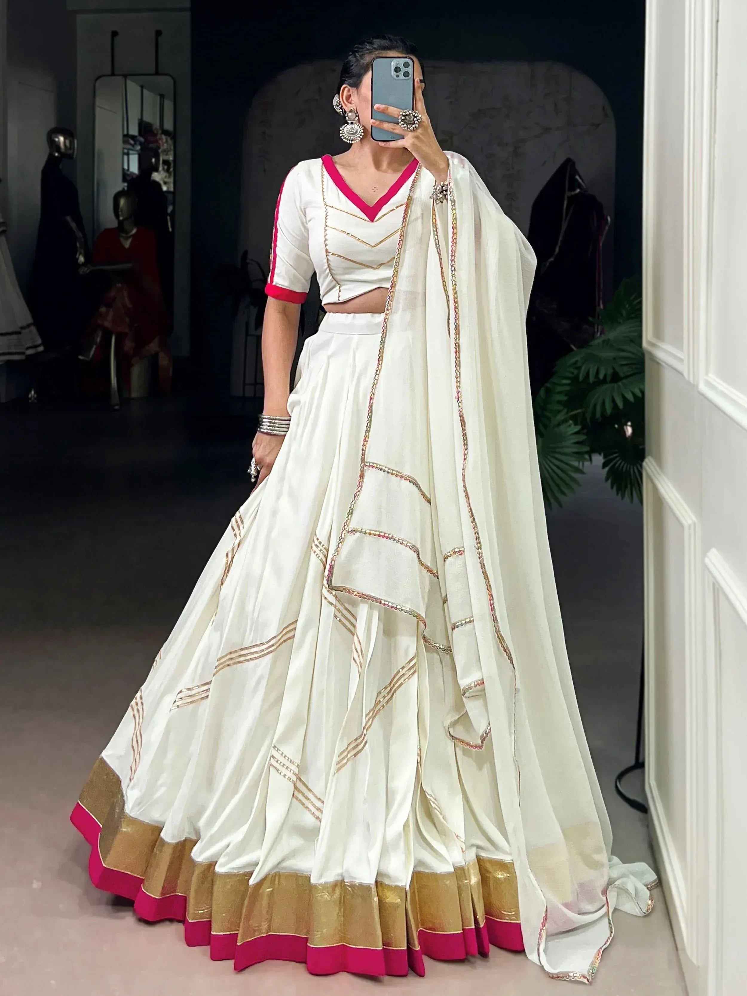 White lehenga choli with pink and gold trim, ethnic Indian wear for weddings or festivals