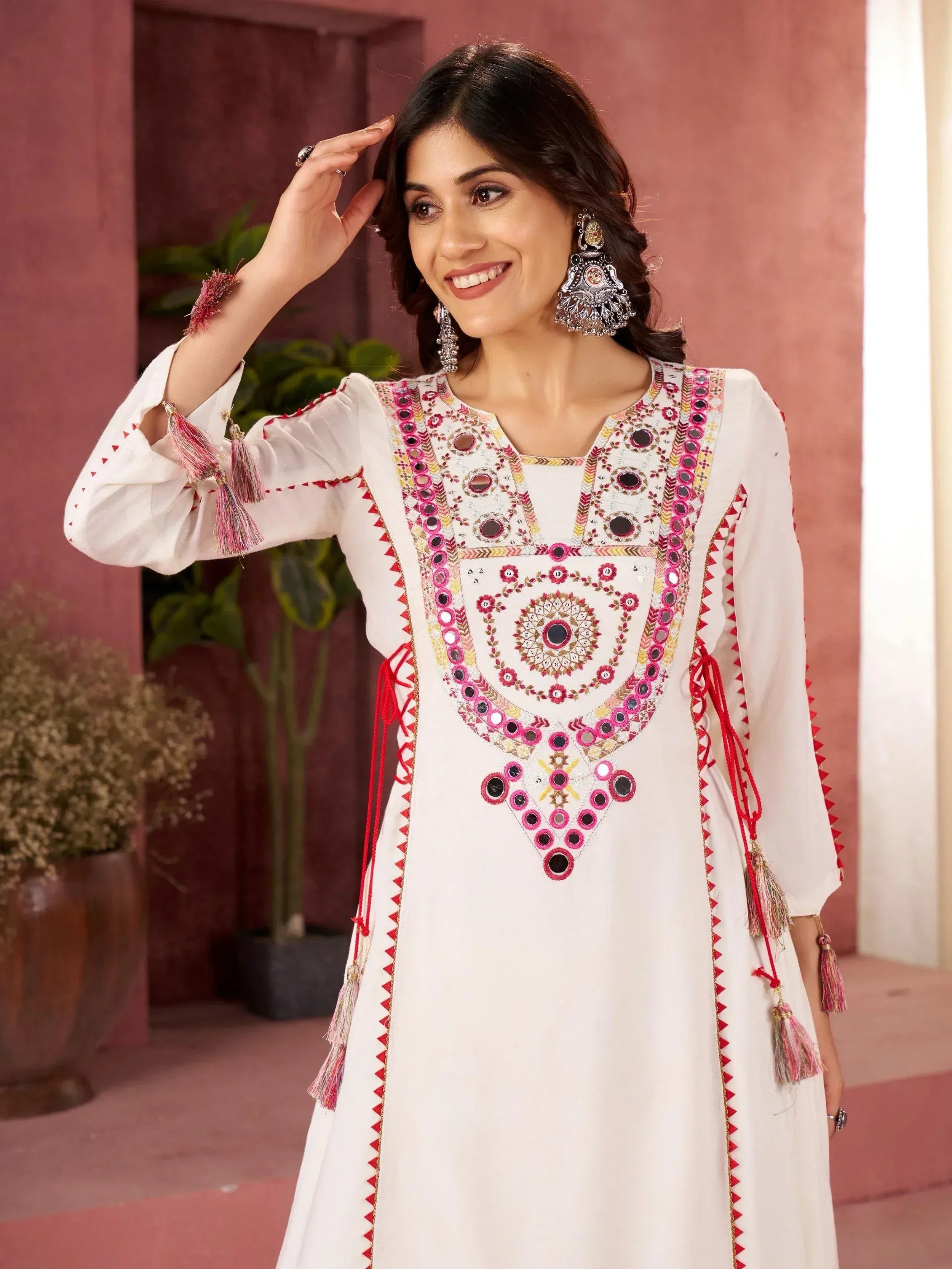 White ethnic kurti with mirror work, tassels, and pink embroidery for Indian wear