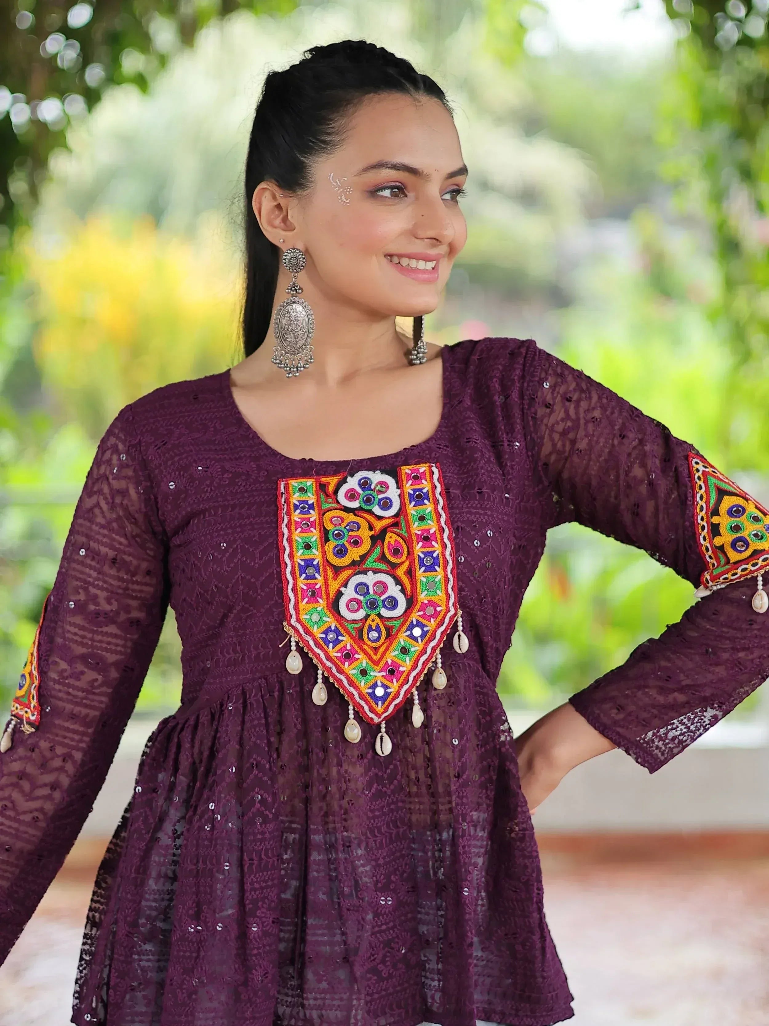 Purple ethnic kurti with colorful mirror embroidery and lace sleeves, styled with traditional earrings