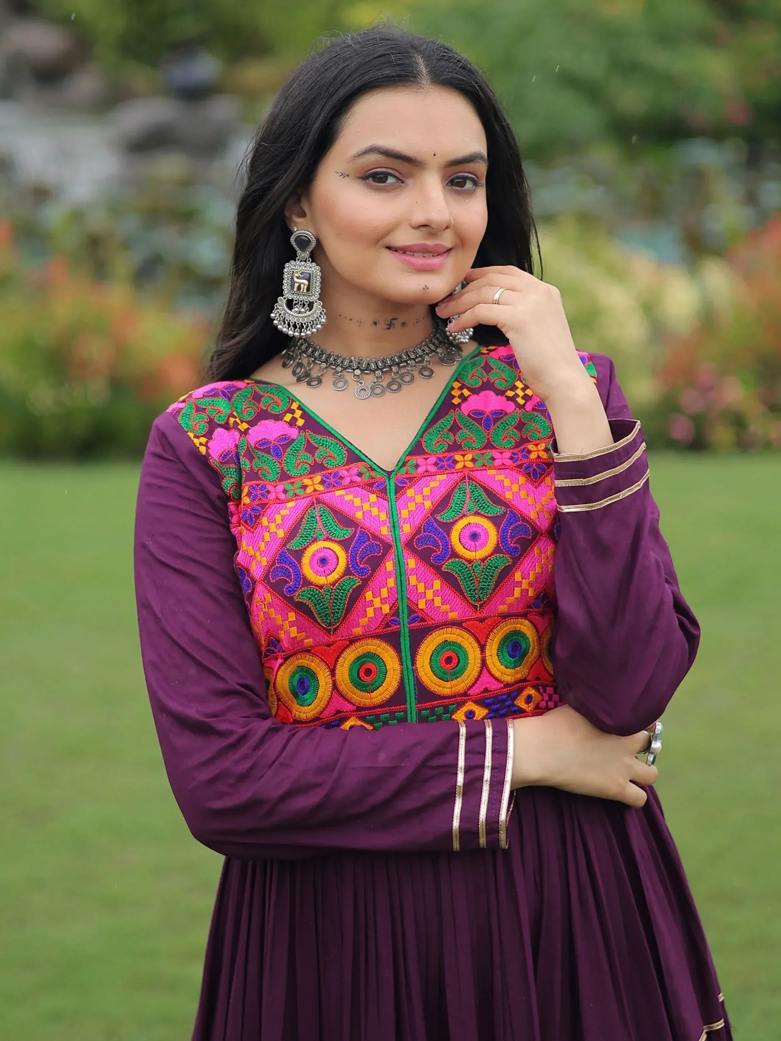 Woman in purple ethnic gown with vibrant embroidery, perfect for Indian festive wear and designer occasions.