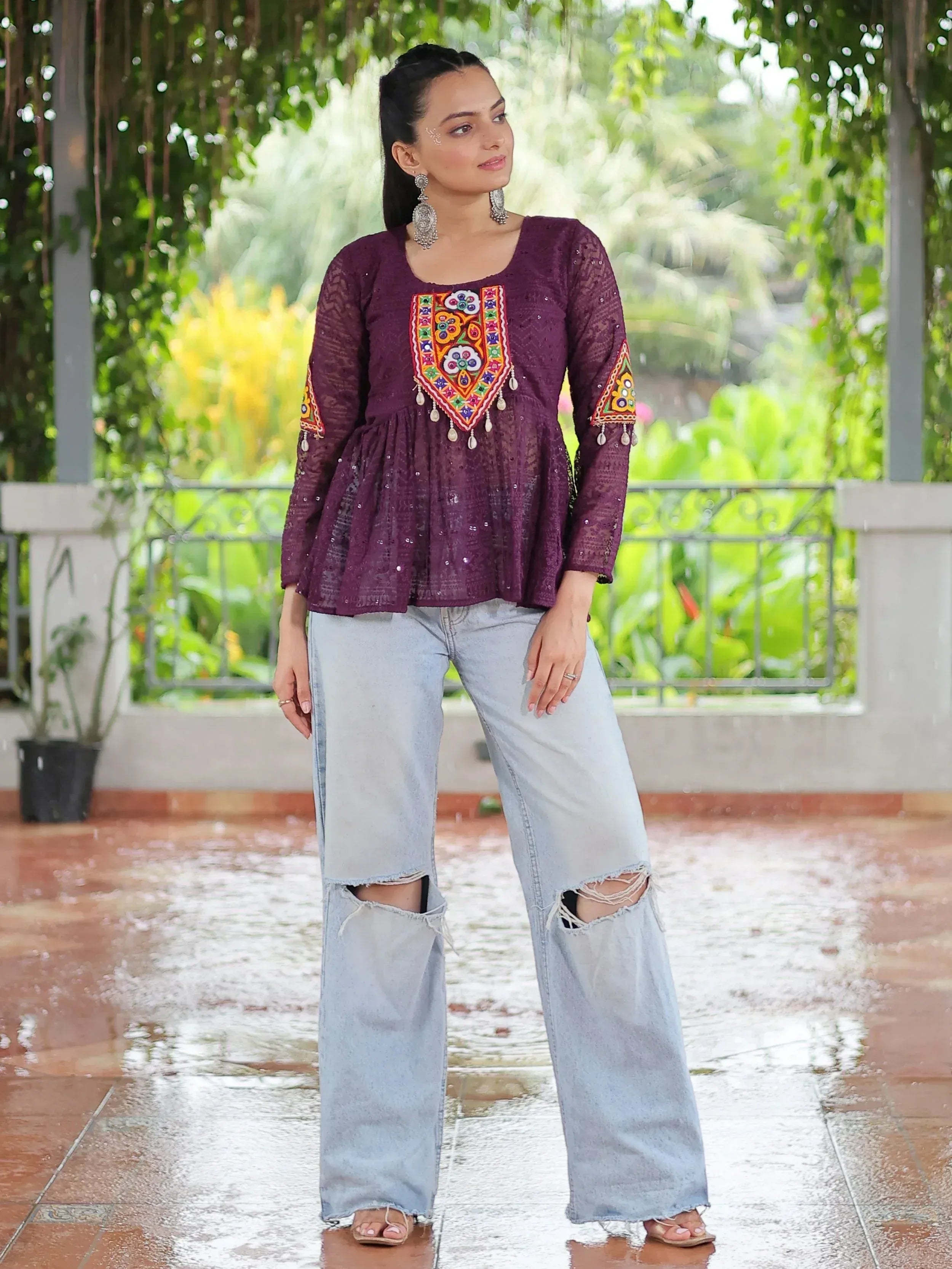 Purple embroidered ethnic top with mirror work, paired with ripped wide-leg jeans, perfect for fusion wear.
