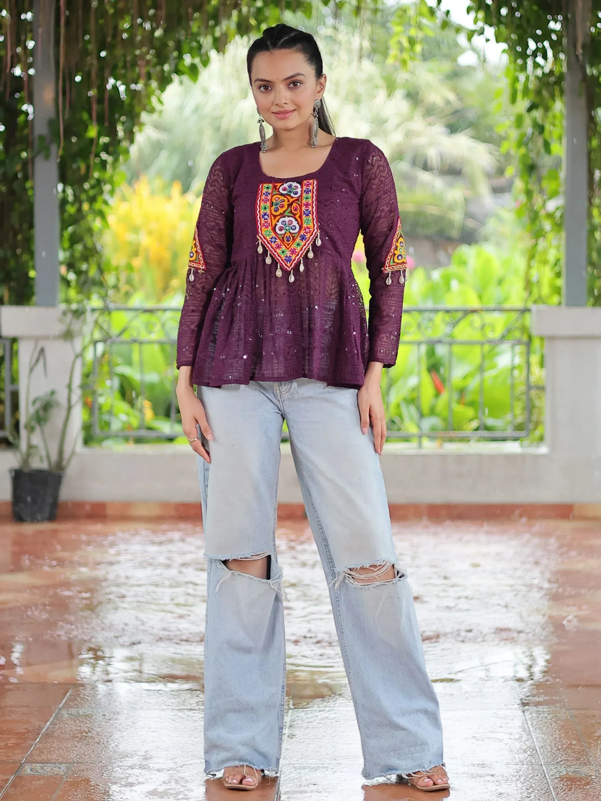 Purple embroidered ethnic top with sequins, paired with ripped jeans, perfect for casual Indian wear