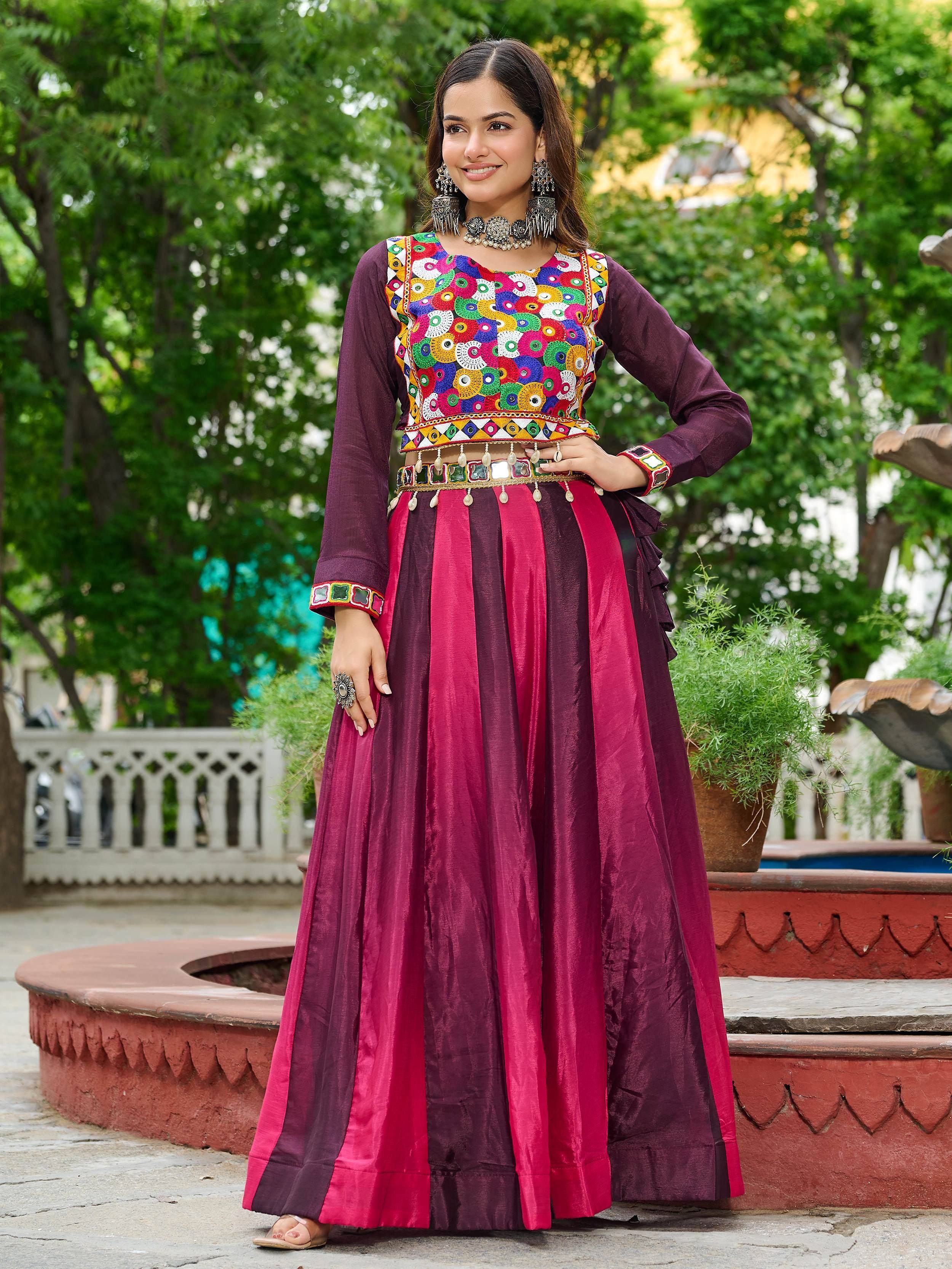 Woman in vibrant Indian ethnic wear with mirror work blouse and maroon-pink striped skirt