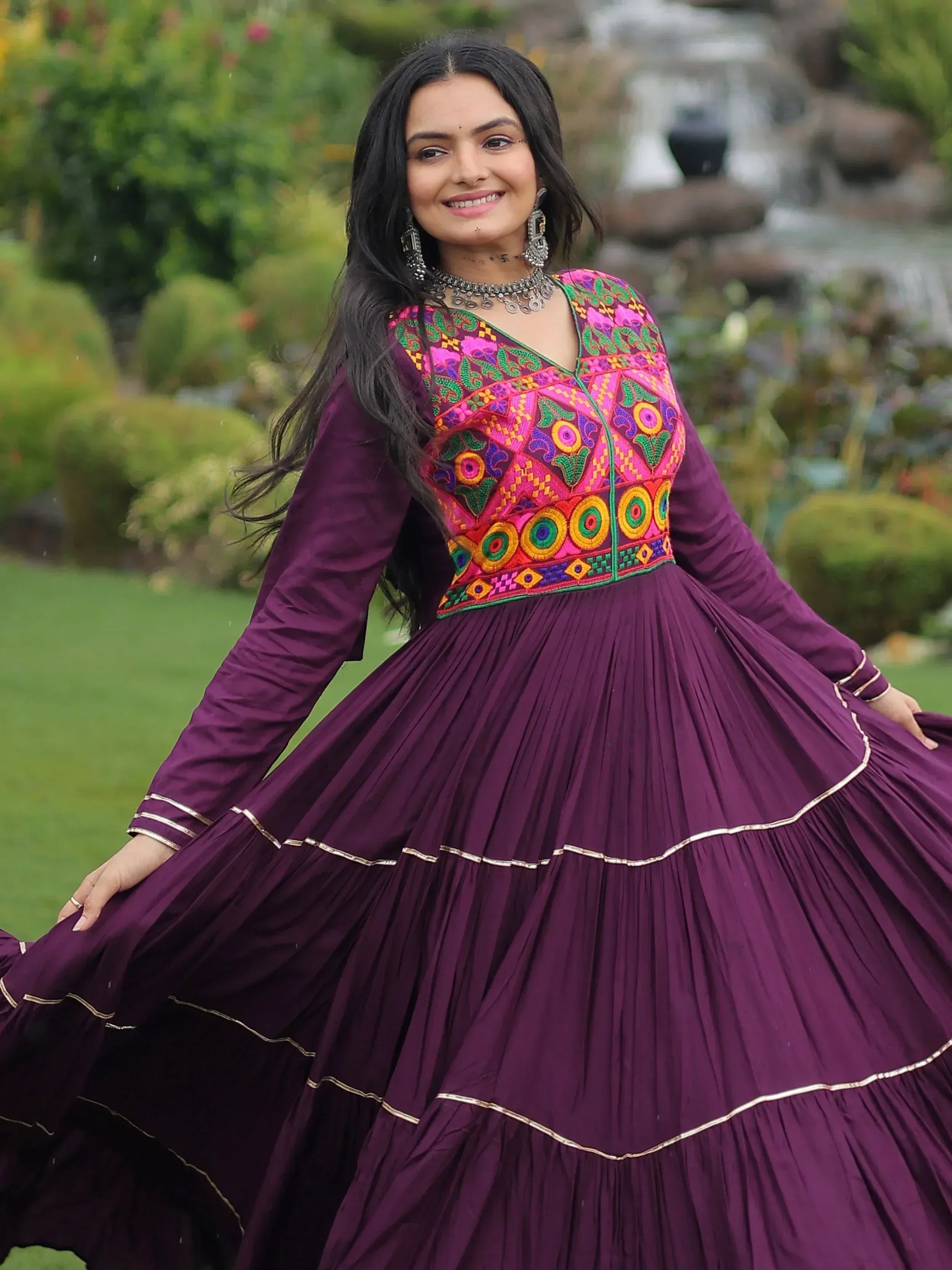 Woman in purple ethnic gown with colorful embroidery, perfect for Indian festive occasions
