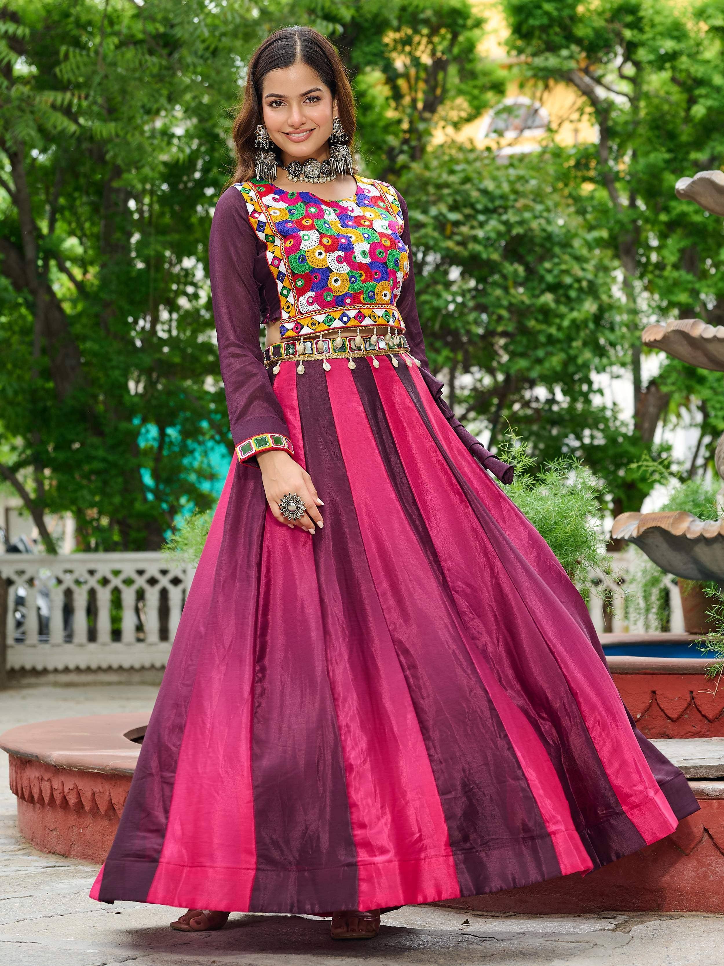 Woman in vibrant Indian ethnic wear with colorful mirror work blouse and striped pink-purple lehenga skirt