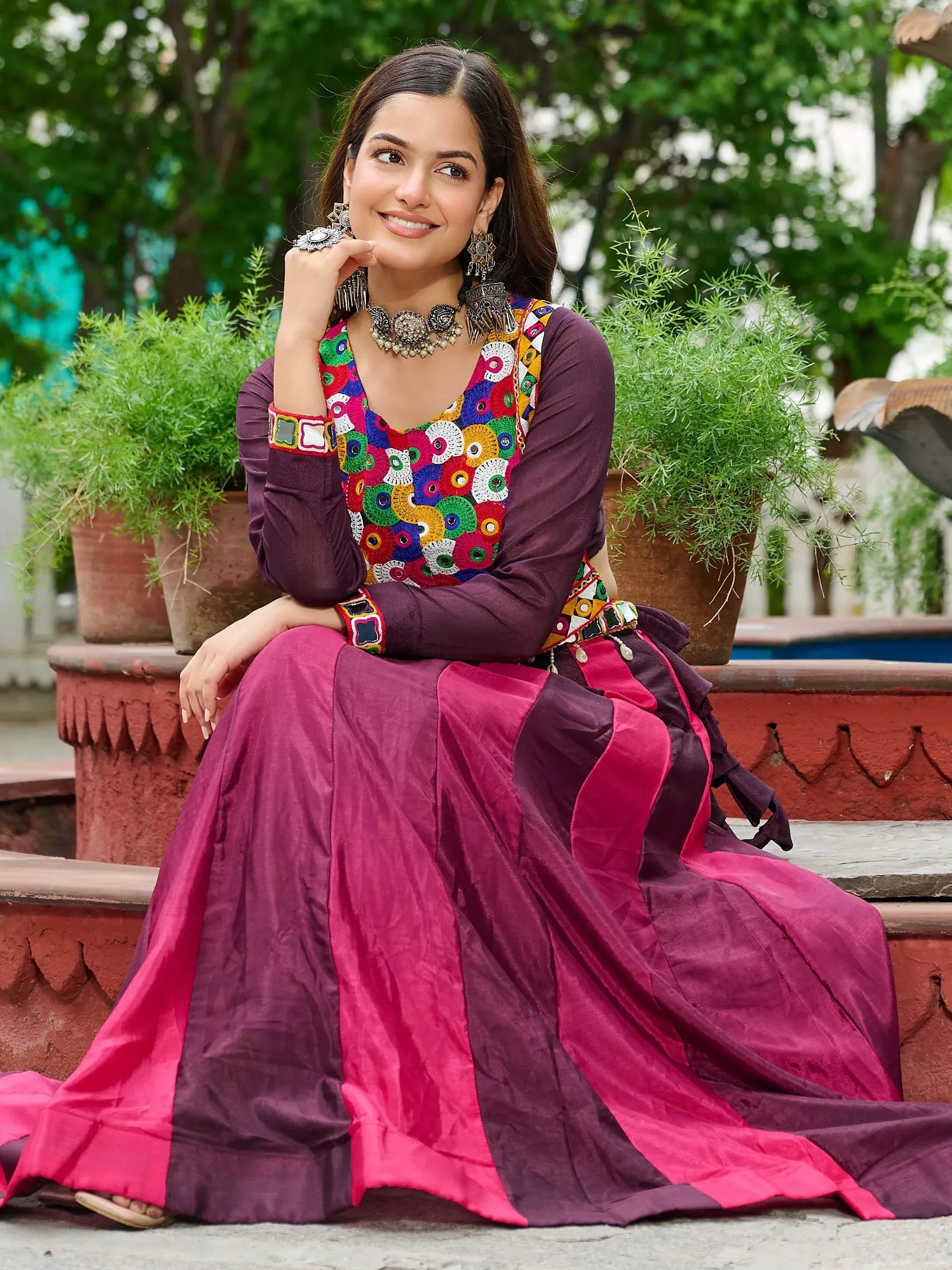 Woman in vibrant ethnic gown with colorful embroidery, perfect for Indian occasions and festivals.