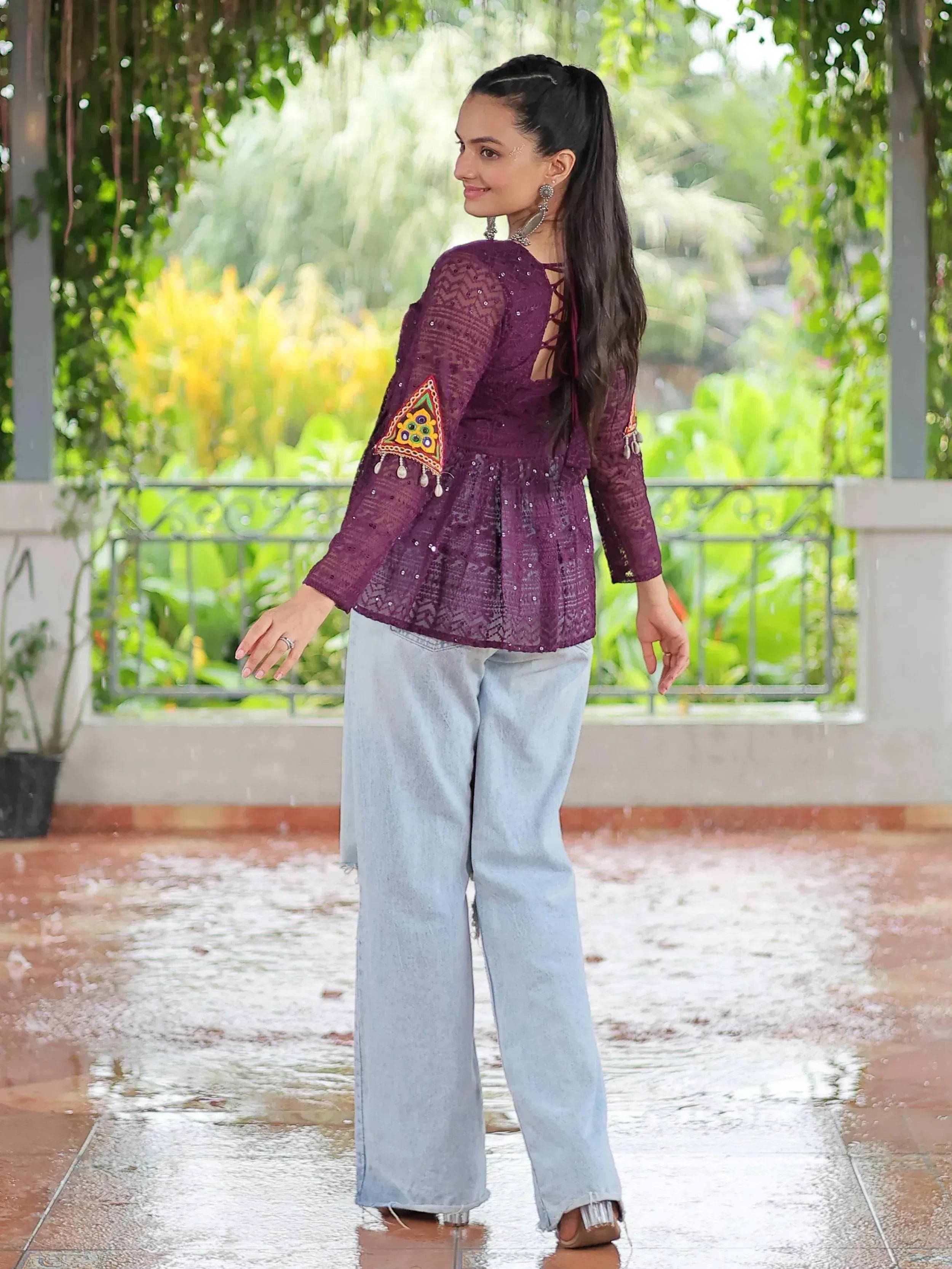 Purple embroidered ethnic top with lace-up back, paired with wide-leg jeans, perfect for casual Indian wear.
