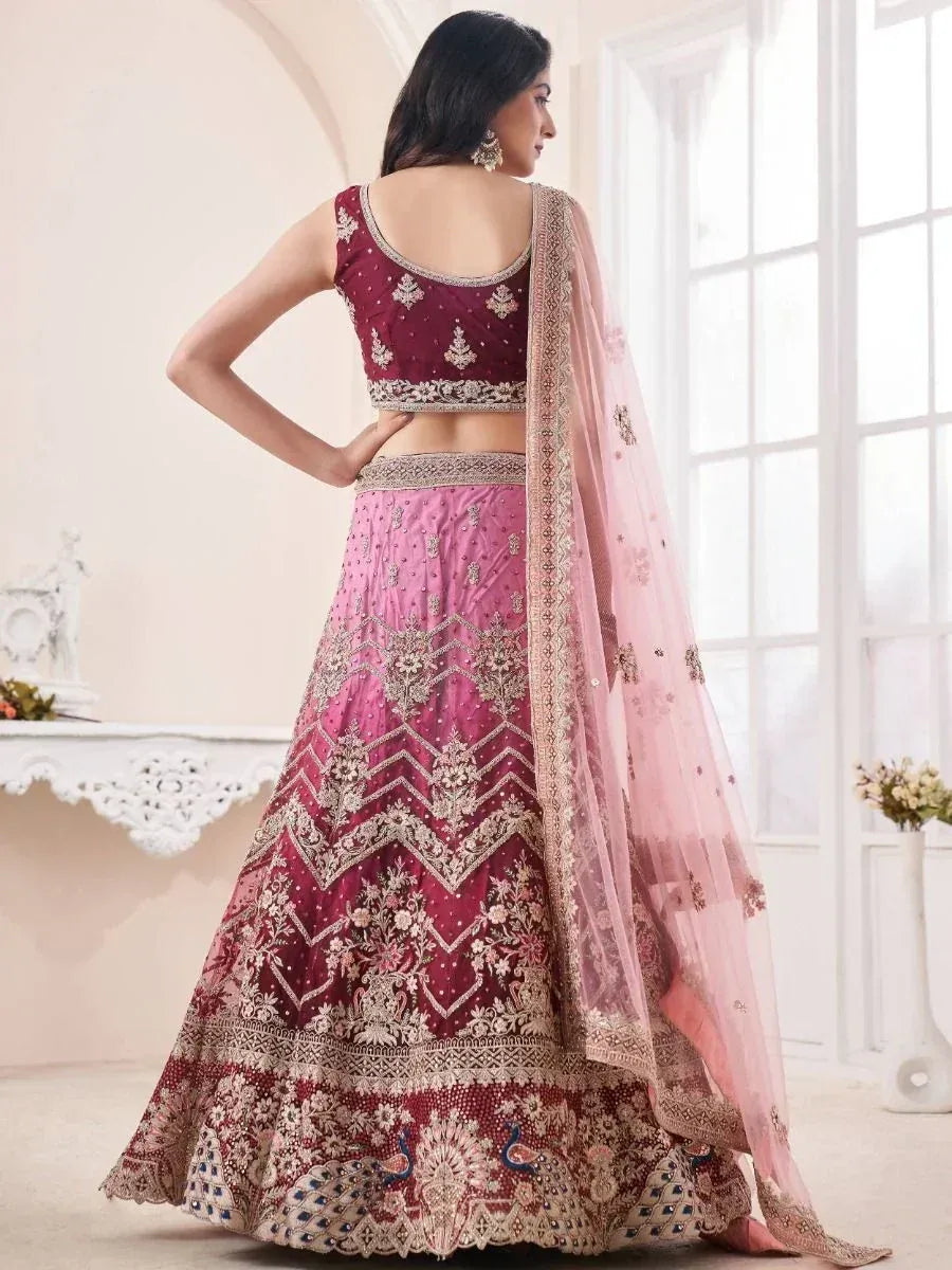 Elegant maroon and pink embroidered lehenga choli with peacock motifs and sheer dupatta, perfect for Indian weddings.