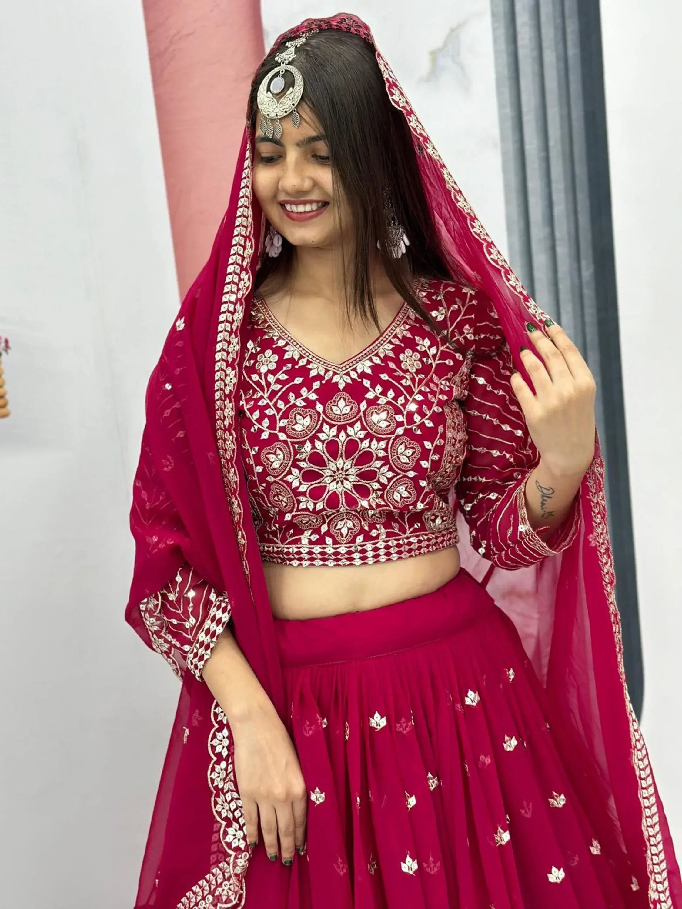 Woman in maroon embroidered lehenga choli with dupatta, traditional Indian ethnic wear