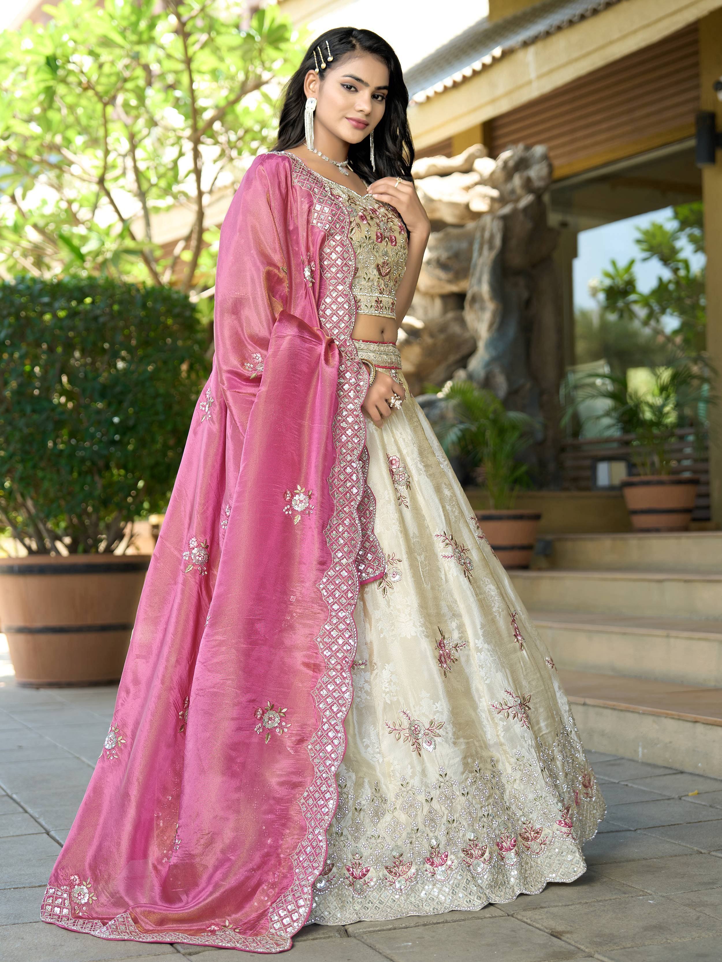 Elegant cream and pink embroidered lehenga choli with floral designs, perfect for Indian ethnic wear.