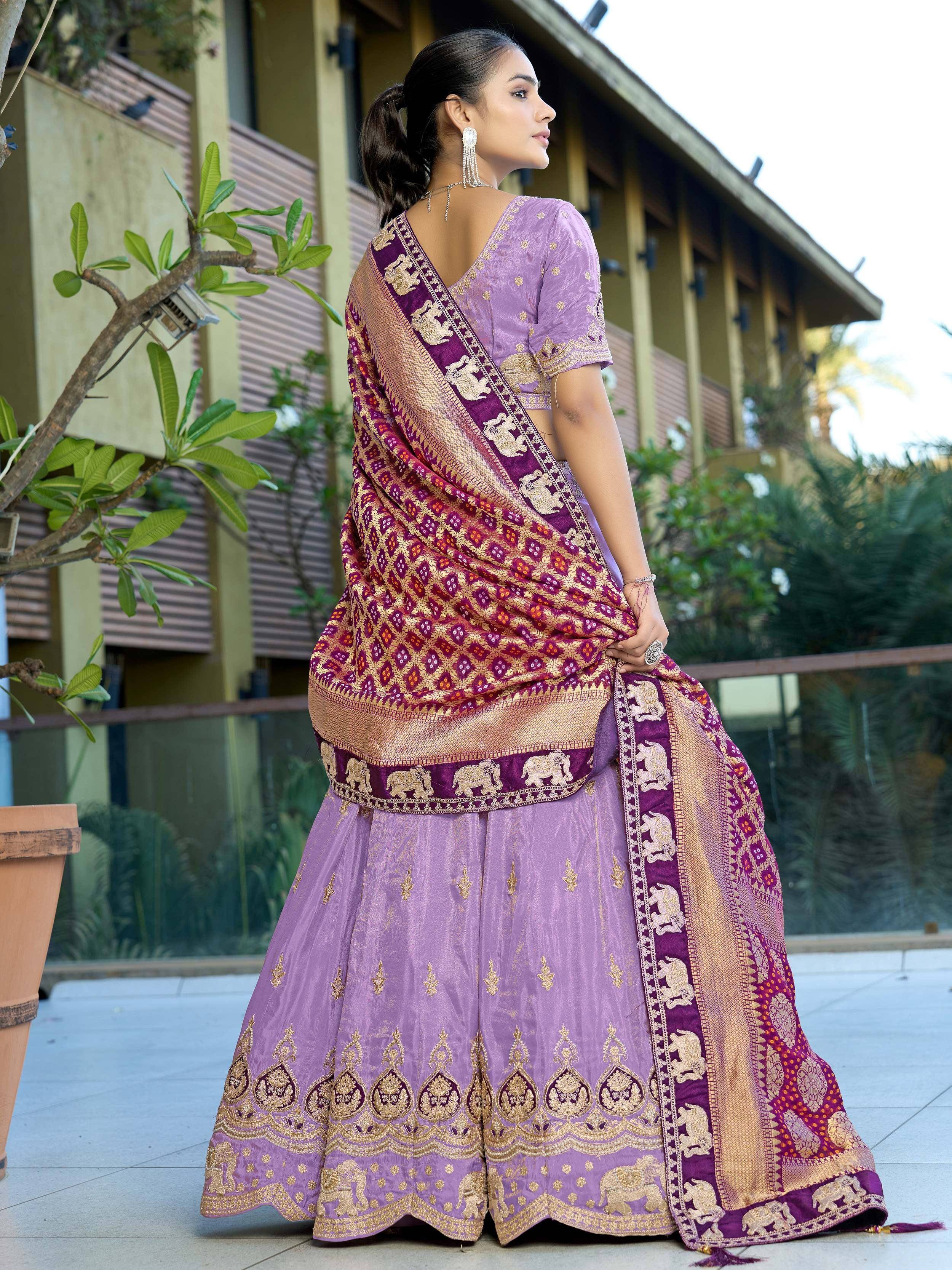 Purple designer lehenga choli with elephant motifs and gold embroidery, paired with a maroon dupatta for Indian ethnic wear.