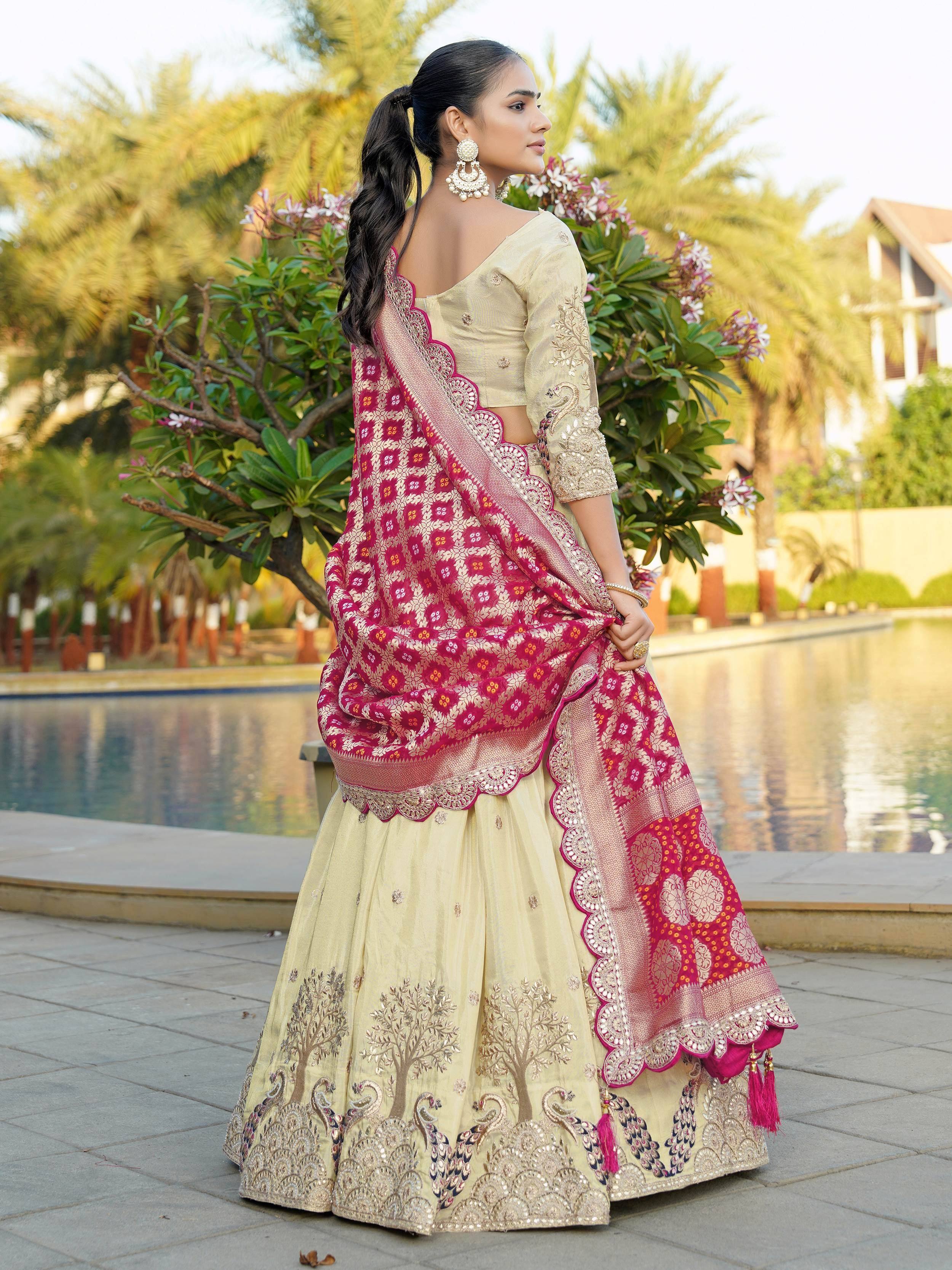 Elegant cream lehenga choli with pink dupatta, intricate embroidery, perfect for Indian weddings and festive occasions.